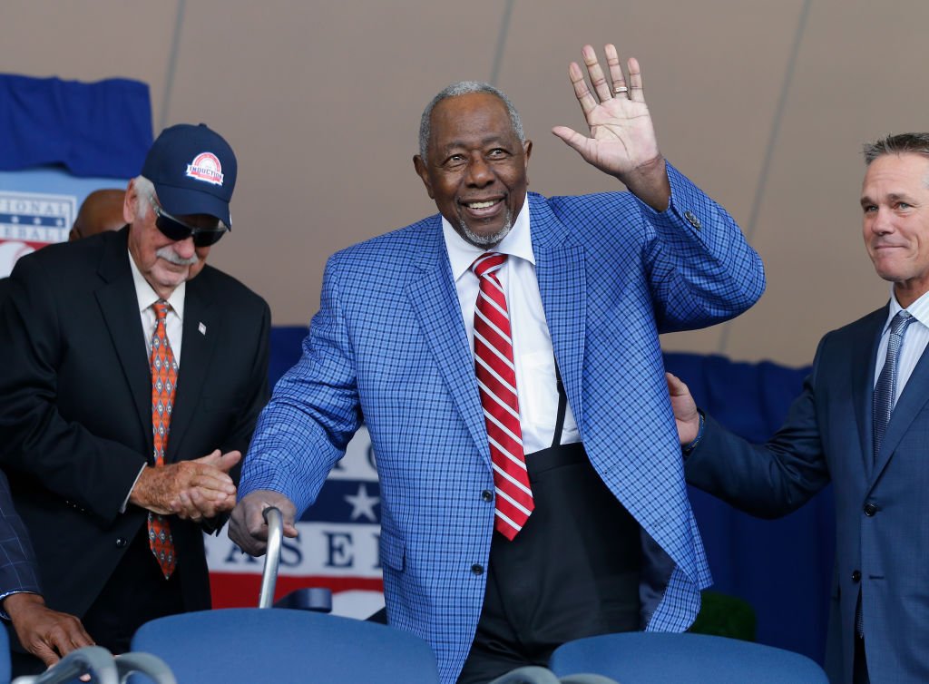 Henry Aaron waving his hand onstage during the Baseball Hall of Fame Induction Ceremony on July 29, 2018 at Clark Sports Center in Cooperstown, New York. | Photo: Getty Images