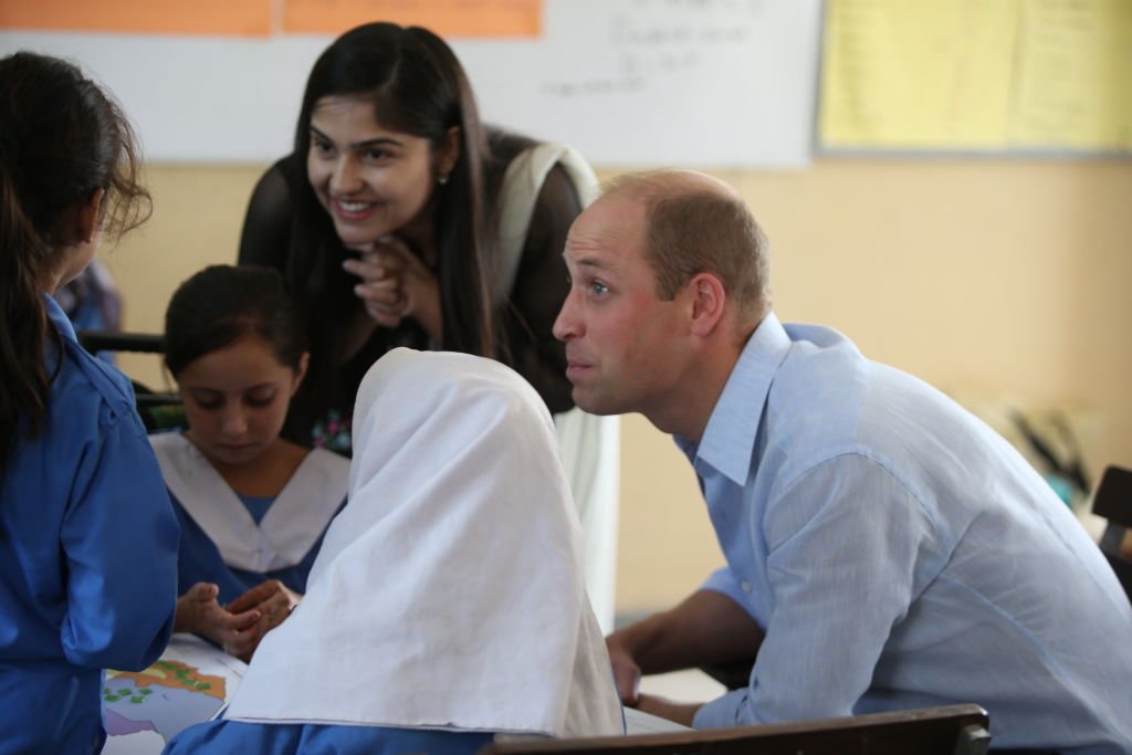 Prince William talking to a student during the visit to a school in Islamabad, Pakistan | Photo: Getty Images