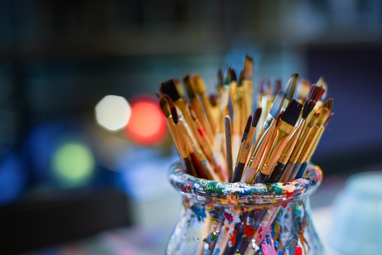 A bunch of different sized paint brushes sitting in a glass jar | Photo: Pixabay/Rudy and Peter Skitterians