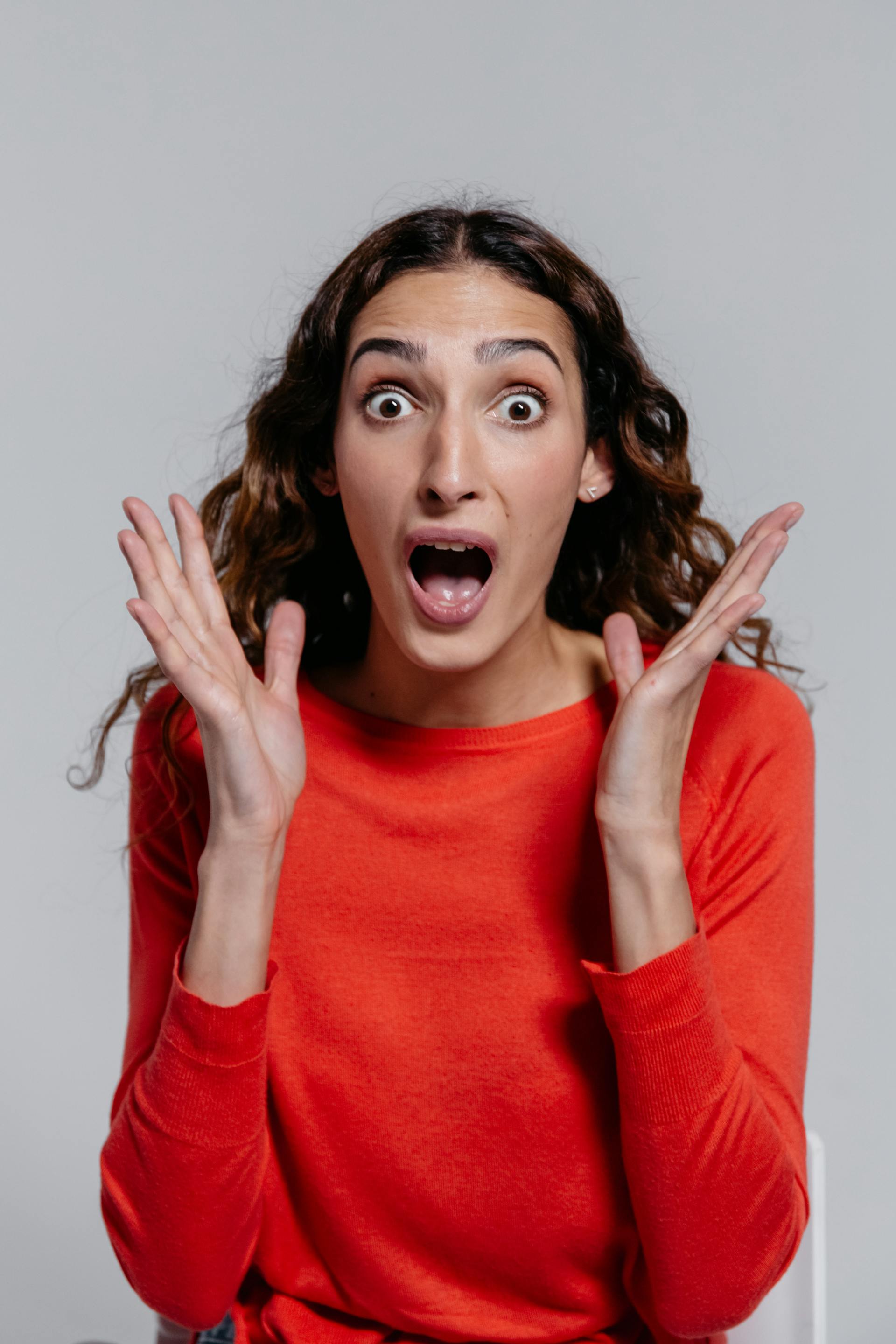 A shocked woman with her hands in the air | Source: Pexels