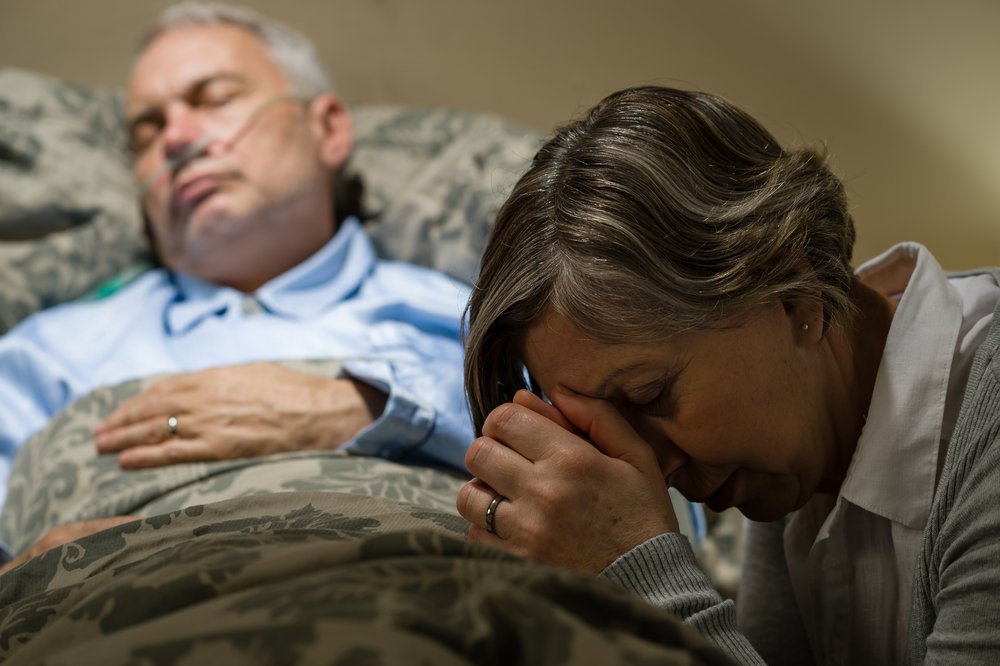 Une vieille femme au chevet de son mari. l Source: Shutterstock Une vieille femme au chevet de son mari. l Source: Shutterstock