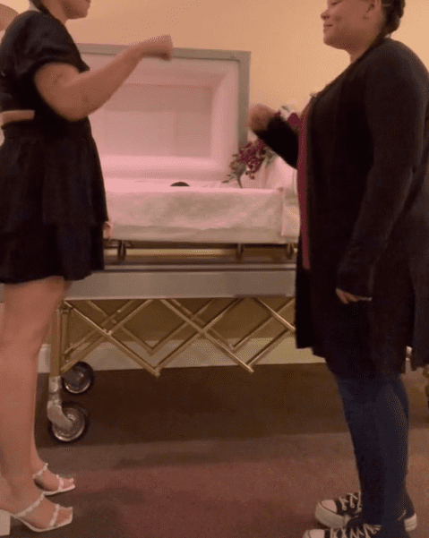  Two sisters fist bumping in front of their late mother's open casket. | Source: tiktok.com/rickandmourning