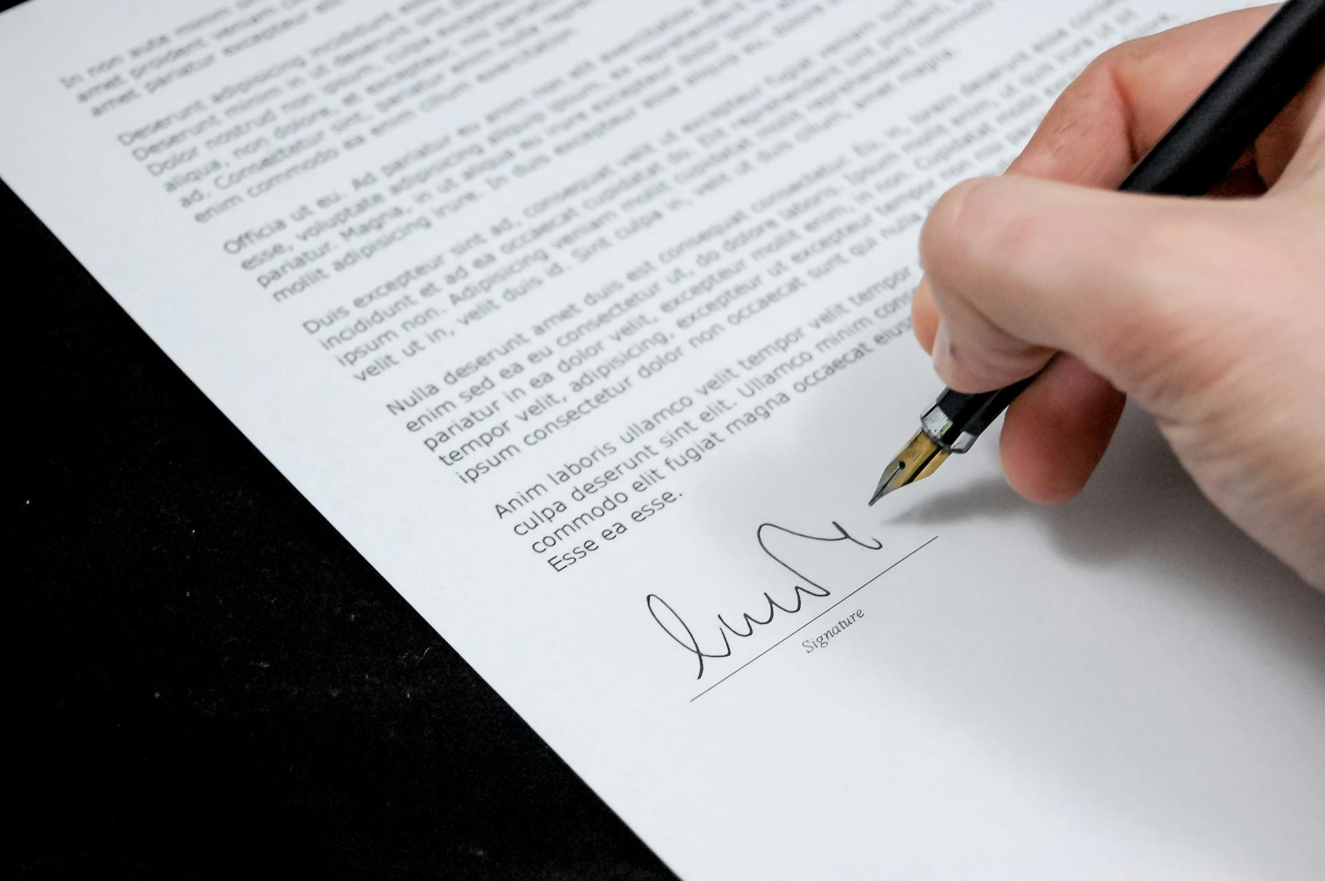 A person signing a written agreement | Source: Pexels