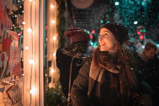 Woman looking through a store window during Christmas | Photo: Getty Images