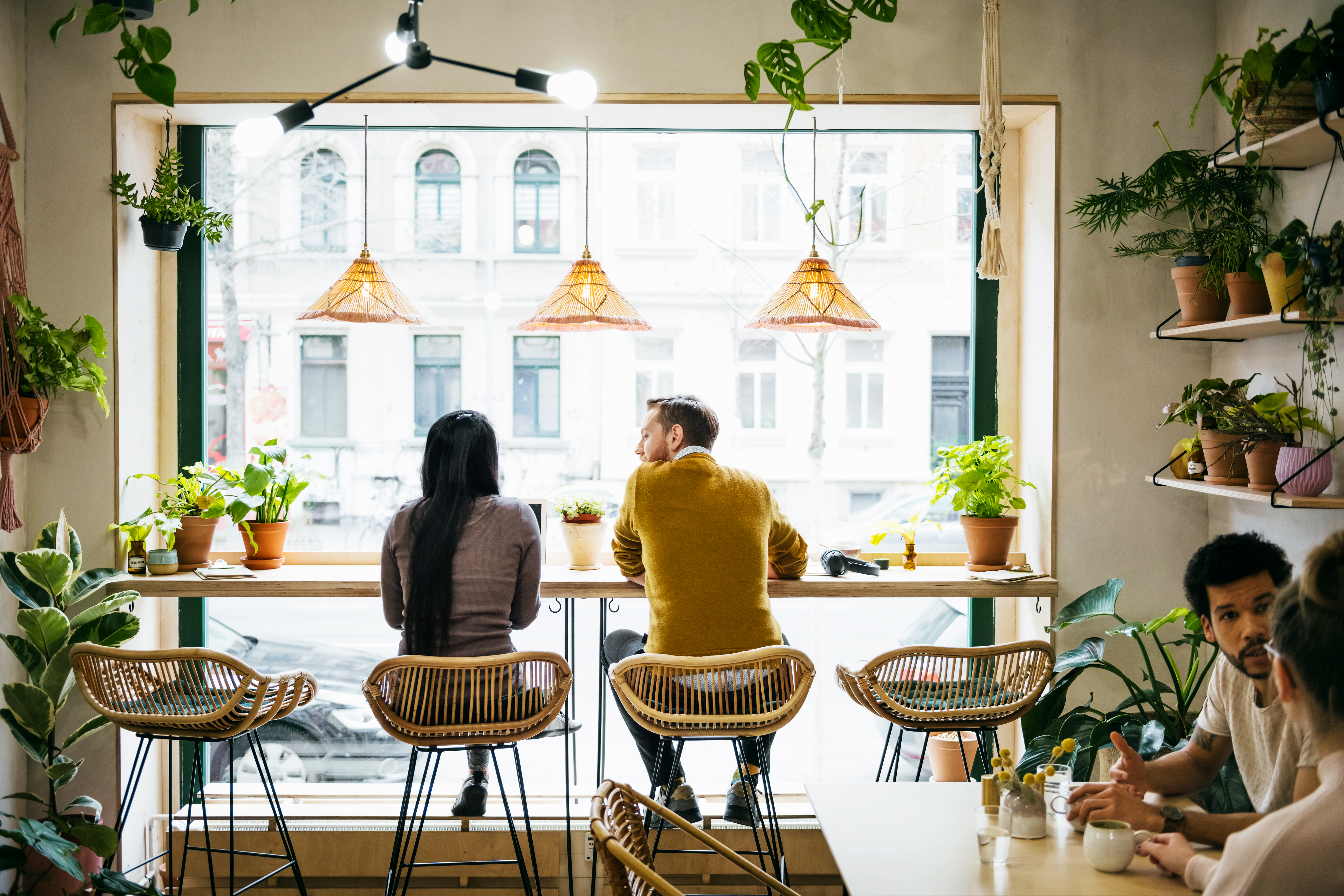 Couple Sitting By Window In Quirky Café | Source: Getty Images