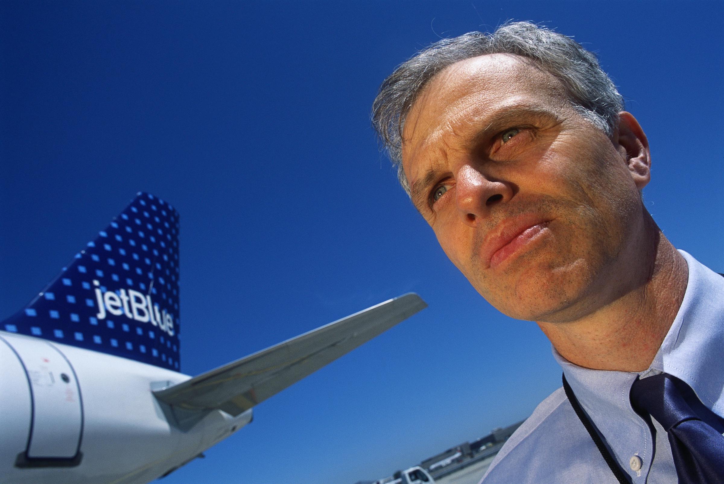 David Neeleman posing alongside one of the planes from his company, JetBlue, in 2001. | Source: Getty Images