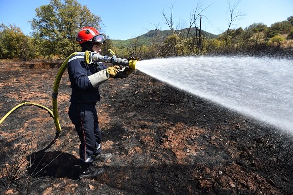 Un pompier pulvérise de l'eau pour éteindre un incendie. |Photo : Getty Images