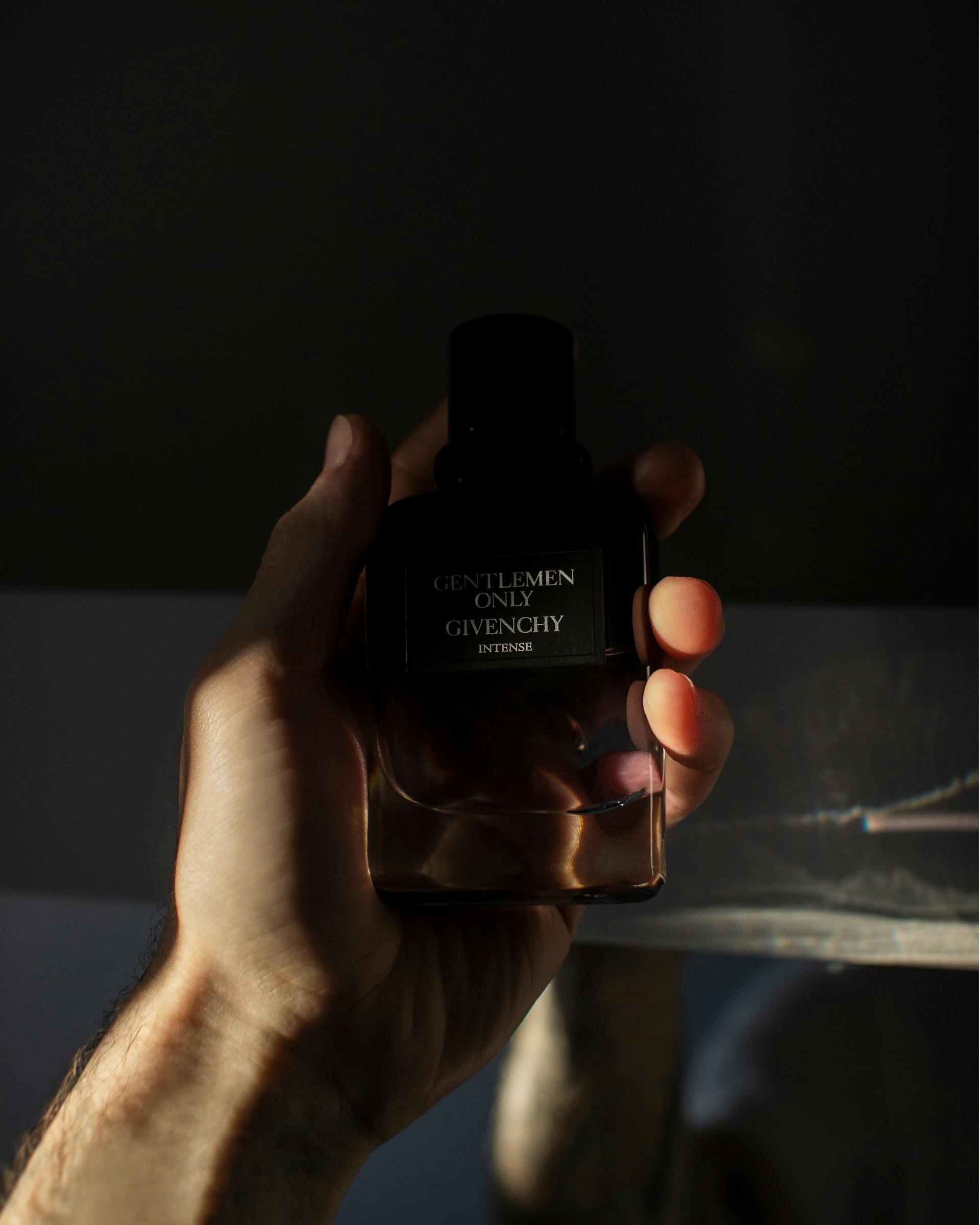 Close-up shot of a man holding a perfume bottle | Source: Pexels