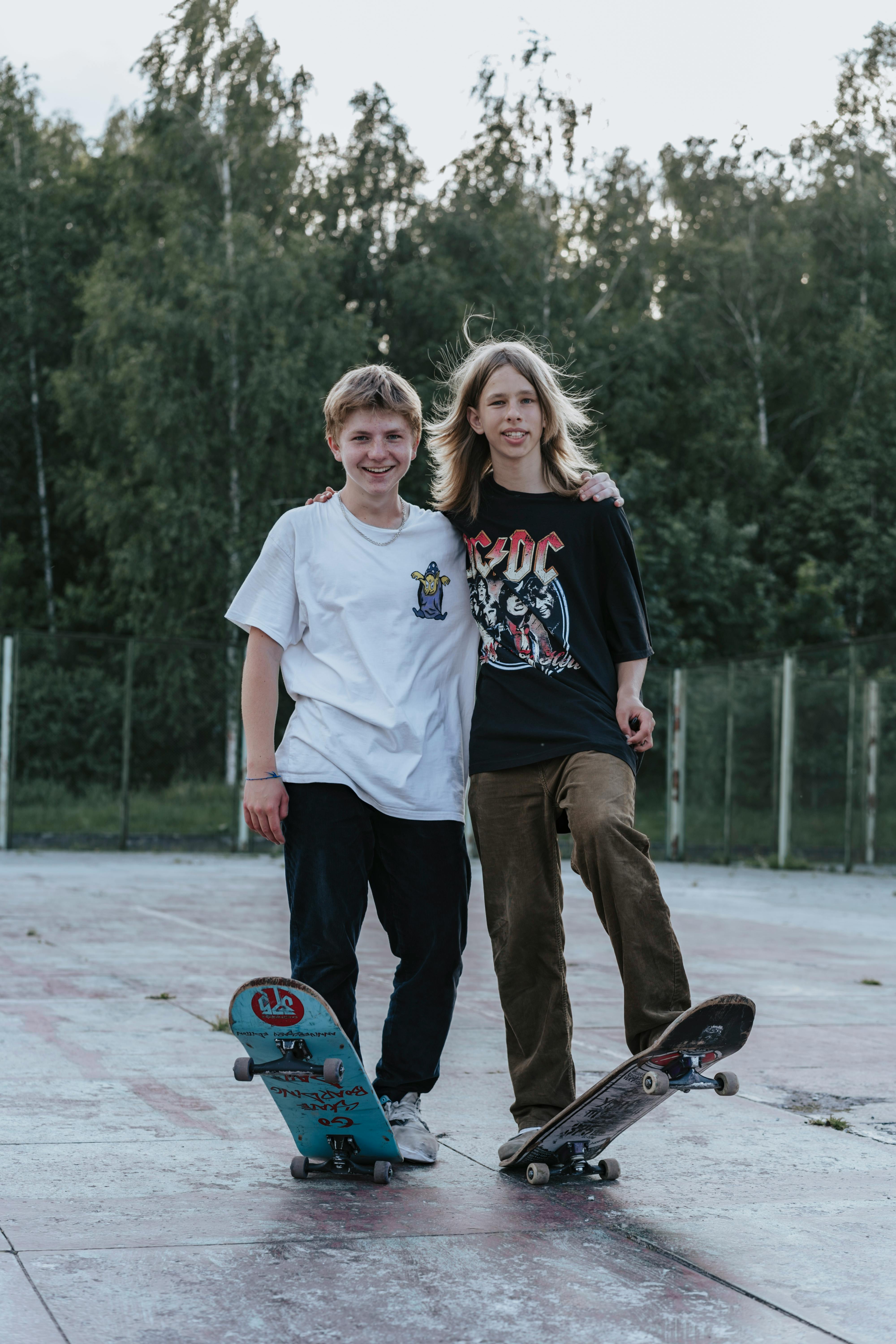 Two young boys standing on skateboards  | Source: Pexels