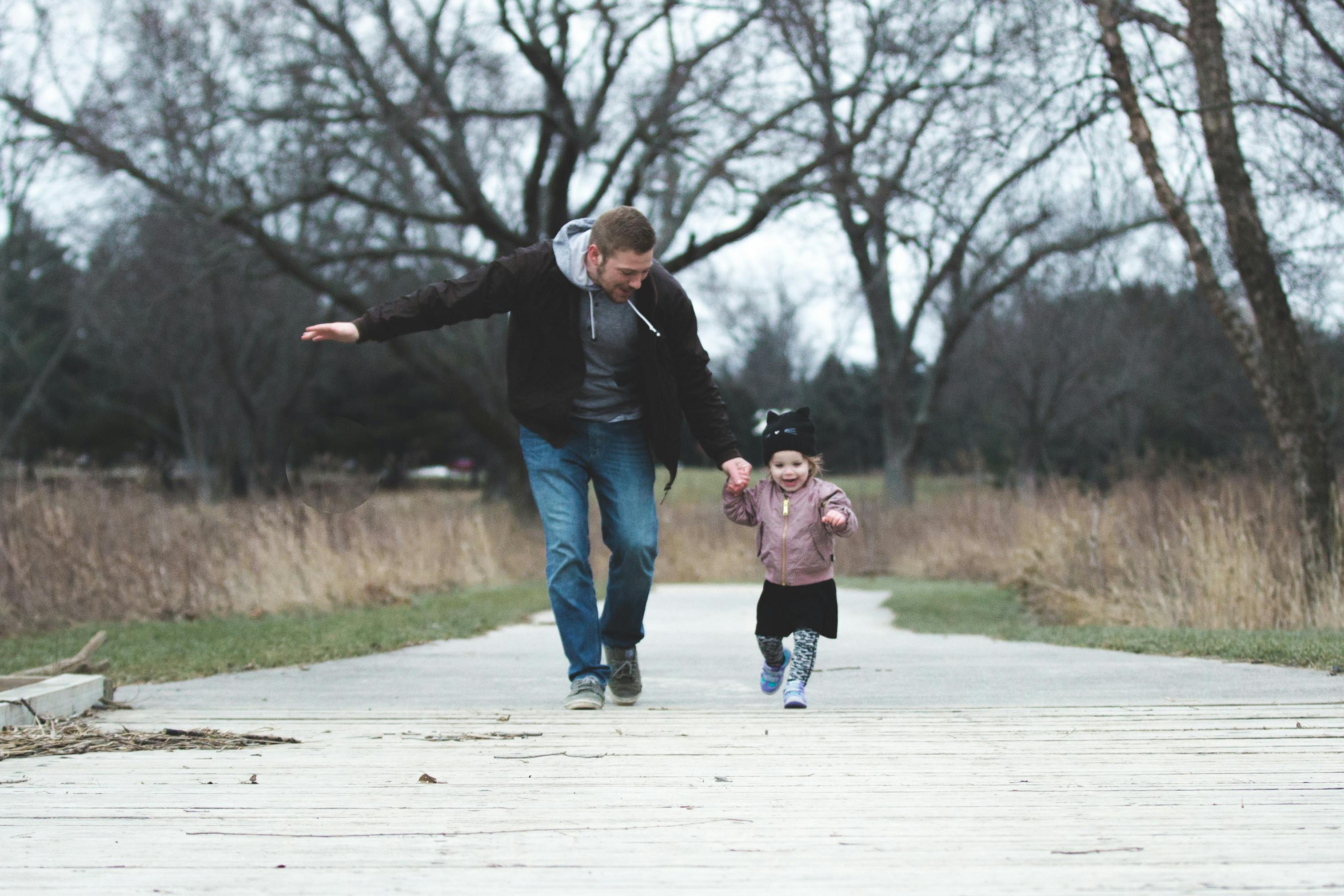 Man runs with his little daughter | Source: Pexels