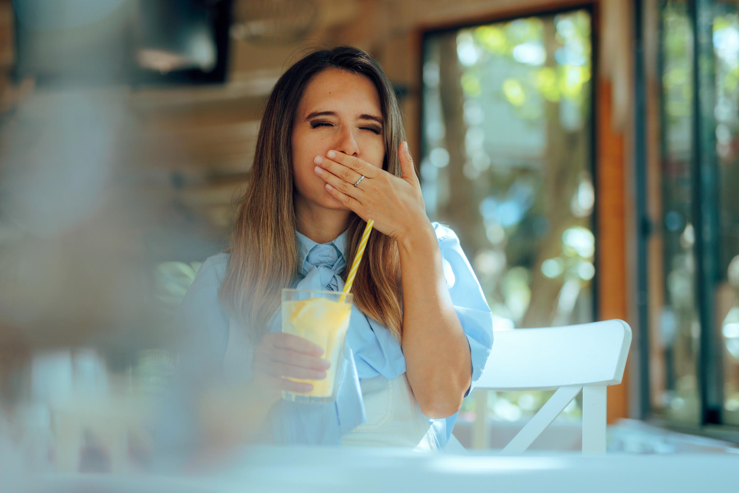A woman covering her mouth after getting hiccups | Source: Getty Images