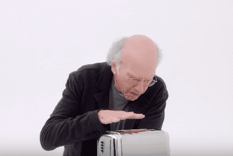Larry David checks if the toaster is working during the promo of the tenth season of "Curb Your Enthusiasm." | Source: YouTube/HBO.
