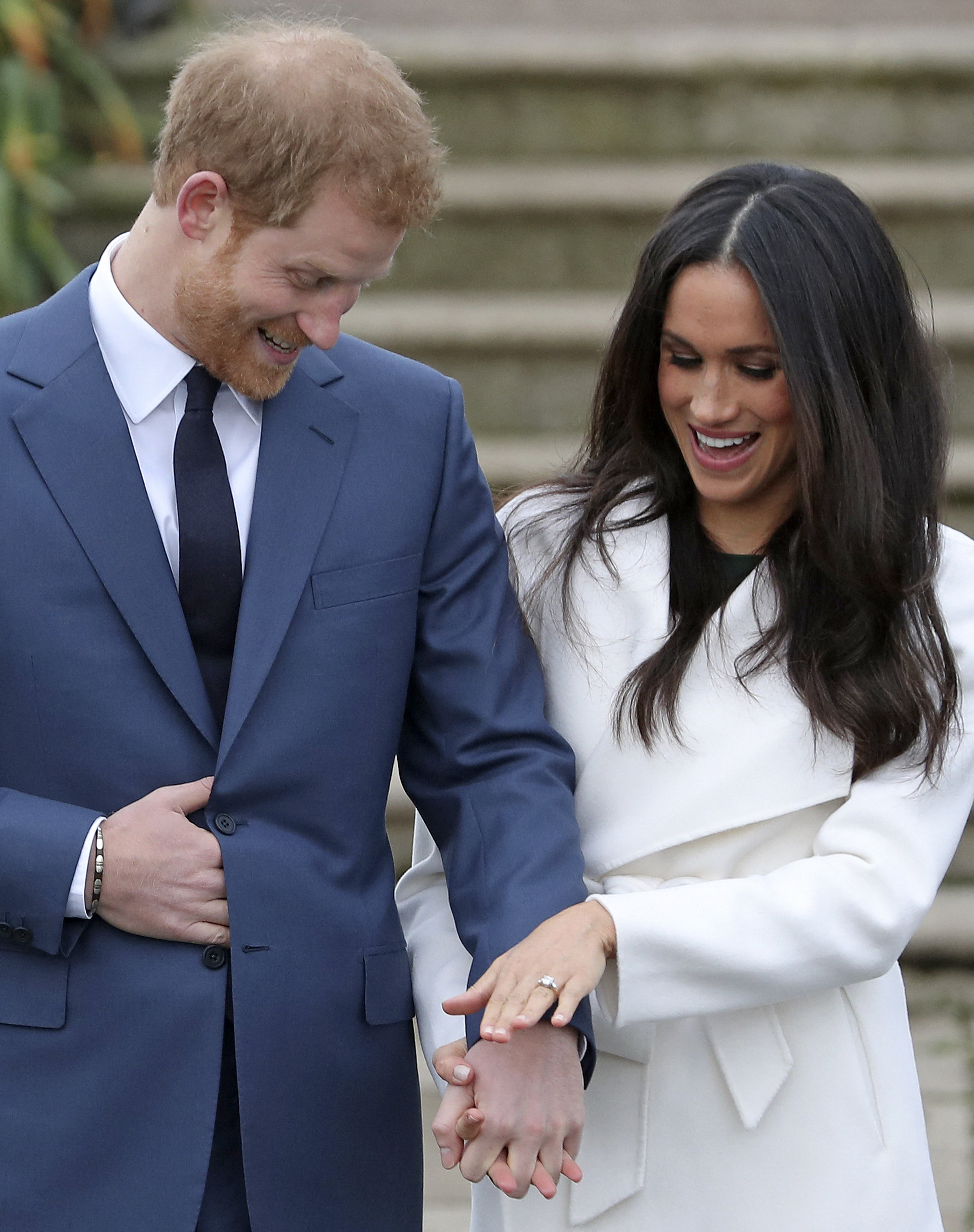 Prince Harry with Meghan Markle as shows off her engagement ring whilst they pose for a photograph in the Sunken Garden at Kensington Palace in west London on November 27, 2017 | Source: Getty Images