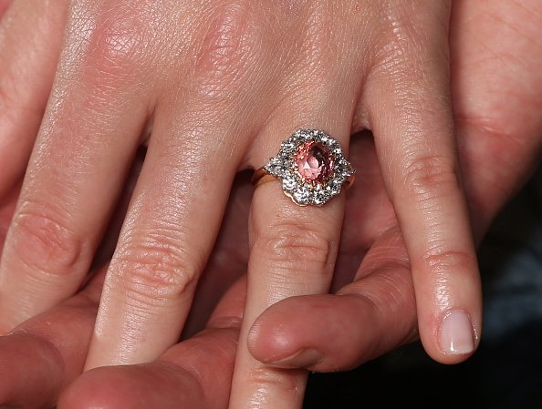 Prinzessin Eugenie trägt einen Ring mit einem Padparadscha-Saphir, umgeben von Diamanten, als sie mit Jack Brooksbank in der Gemäldegalerie des Buckingham Palace in London posiert, nachdem sie ihre Verlobung bekannt gegeben haben | Quelle: Getty Images
