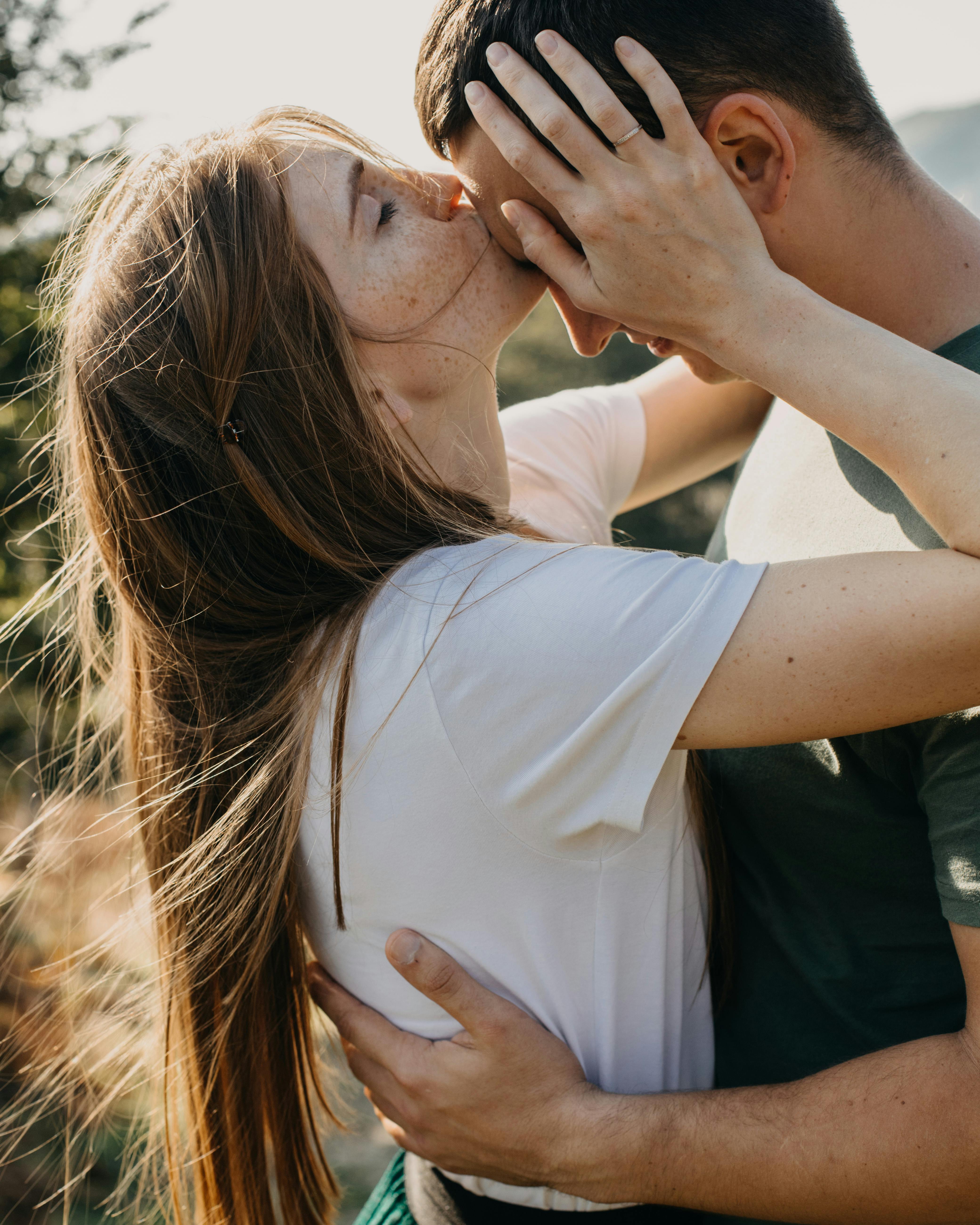 A woman kissing her partner on his forehead | Source: Pexels