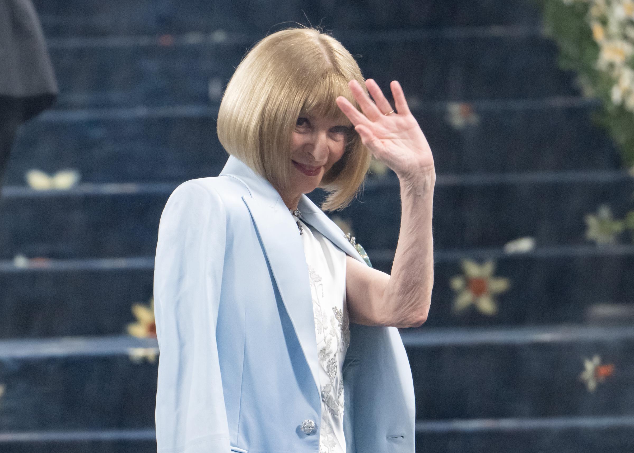 Anna Wintour waves at onlookers as she makes her way up the carpeted stairs at the 2025 Met Gala. The evening spotlighted "Superfine: Tailoring Black Style" and championed fashion as a form of identity and storytelling.