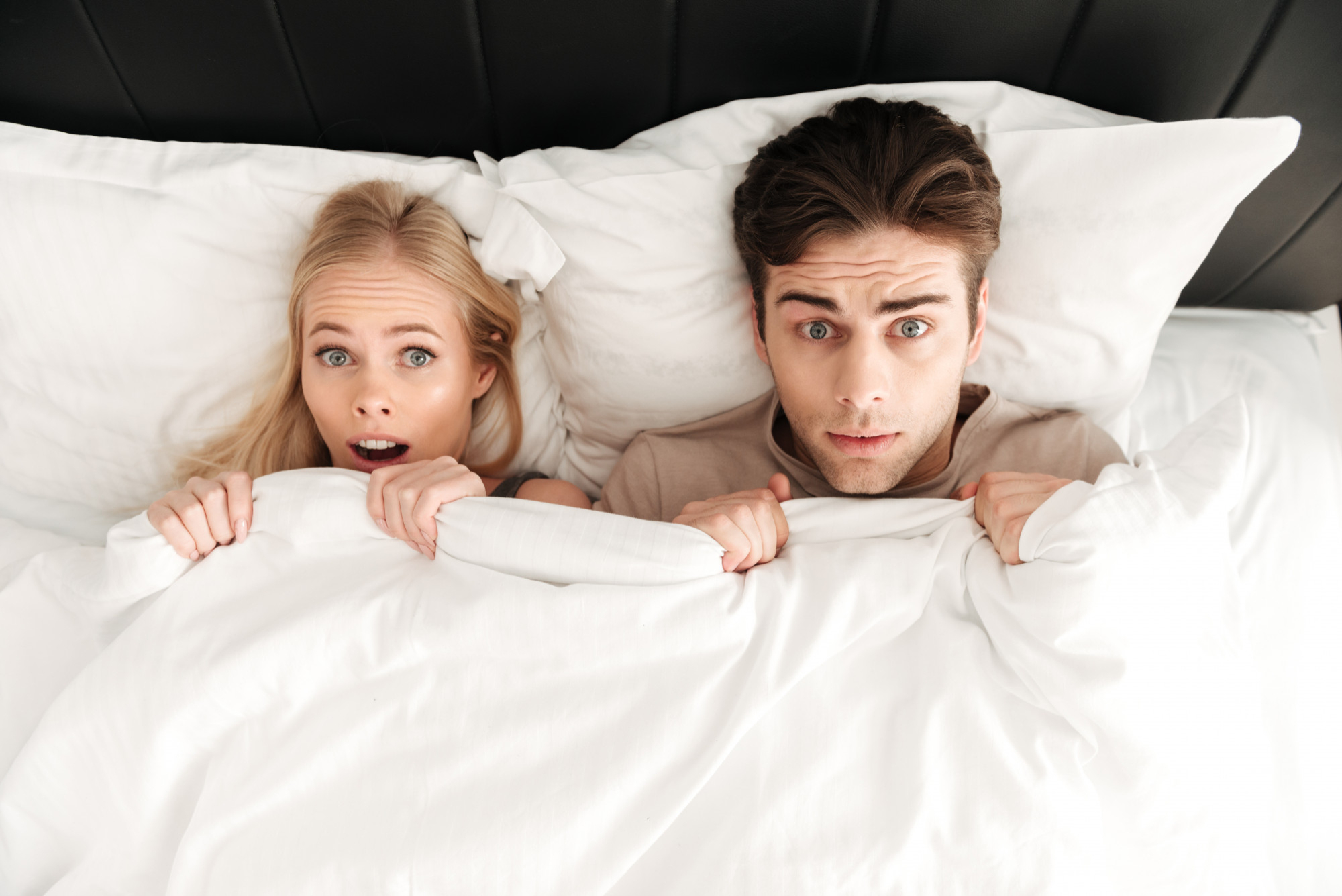 A couple caught in bed together | Source: Freepik