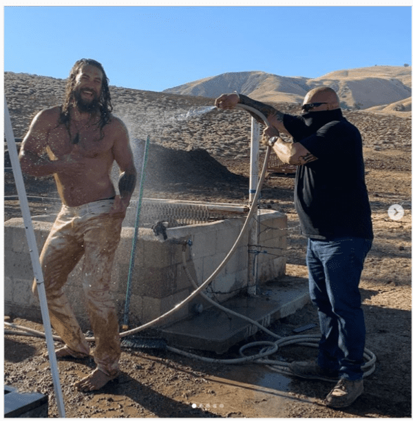 Jason Momoa being washed down with water after a dune buggy ride. | Photo: instagram.com/prideofgypsies