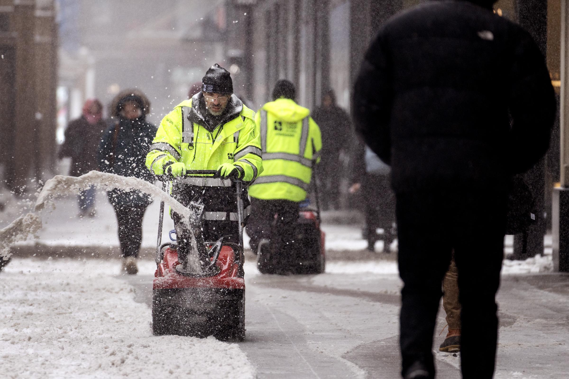 A worker clears snow from a sidewalk in the Loop on February 12, 2025, in Chicago, Illinois. | Source: Getty Images