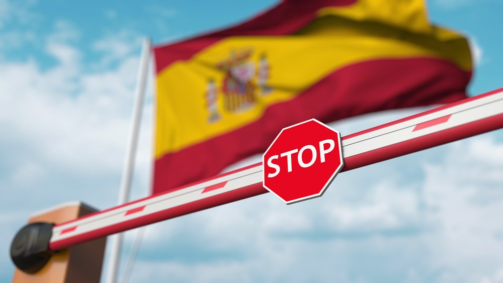 Bandera de España detrás de una barra de detención. | Foto: Shutterstock