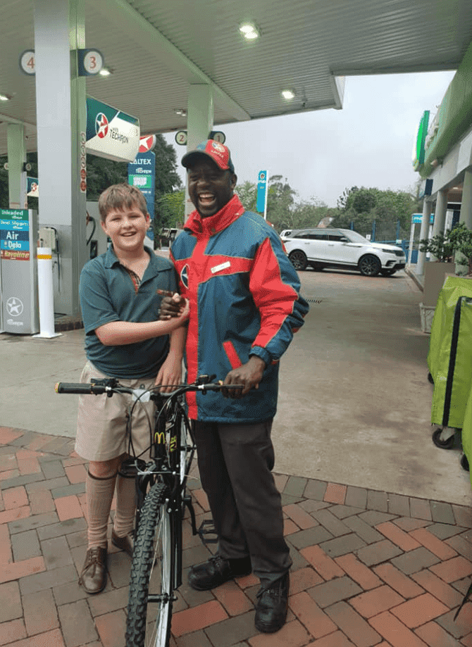 An elated Tony accepting the bike from his 10-year-old friend, Vaughn. | Photo: Facebook/Mandy Moo Fish.
