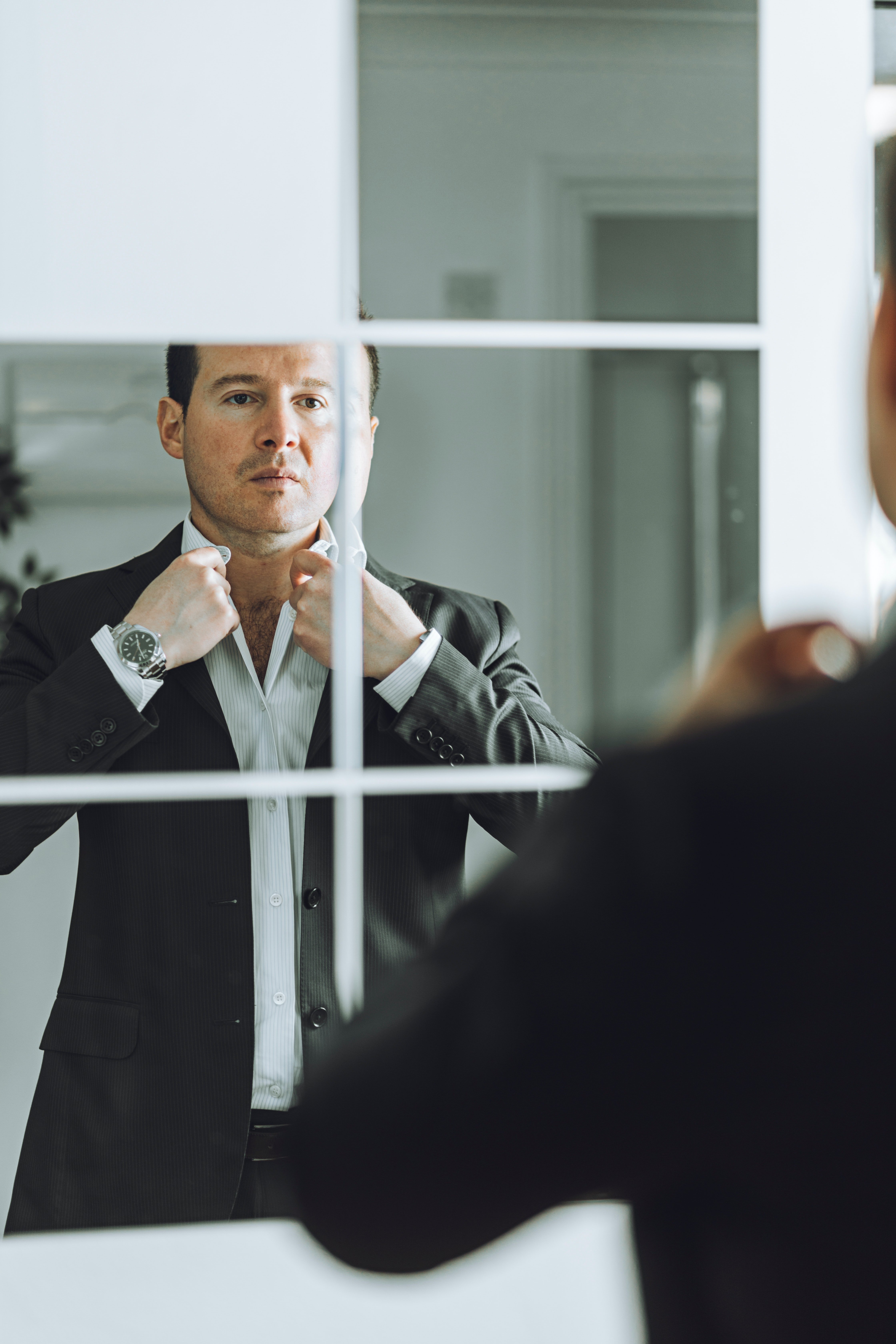 Un hombre elegante se arregla frente al espejo. | Foto: Unsplash