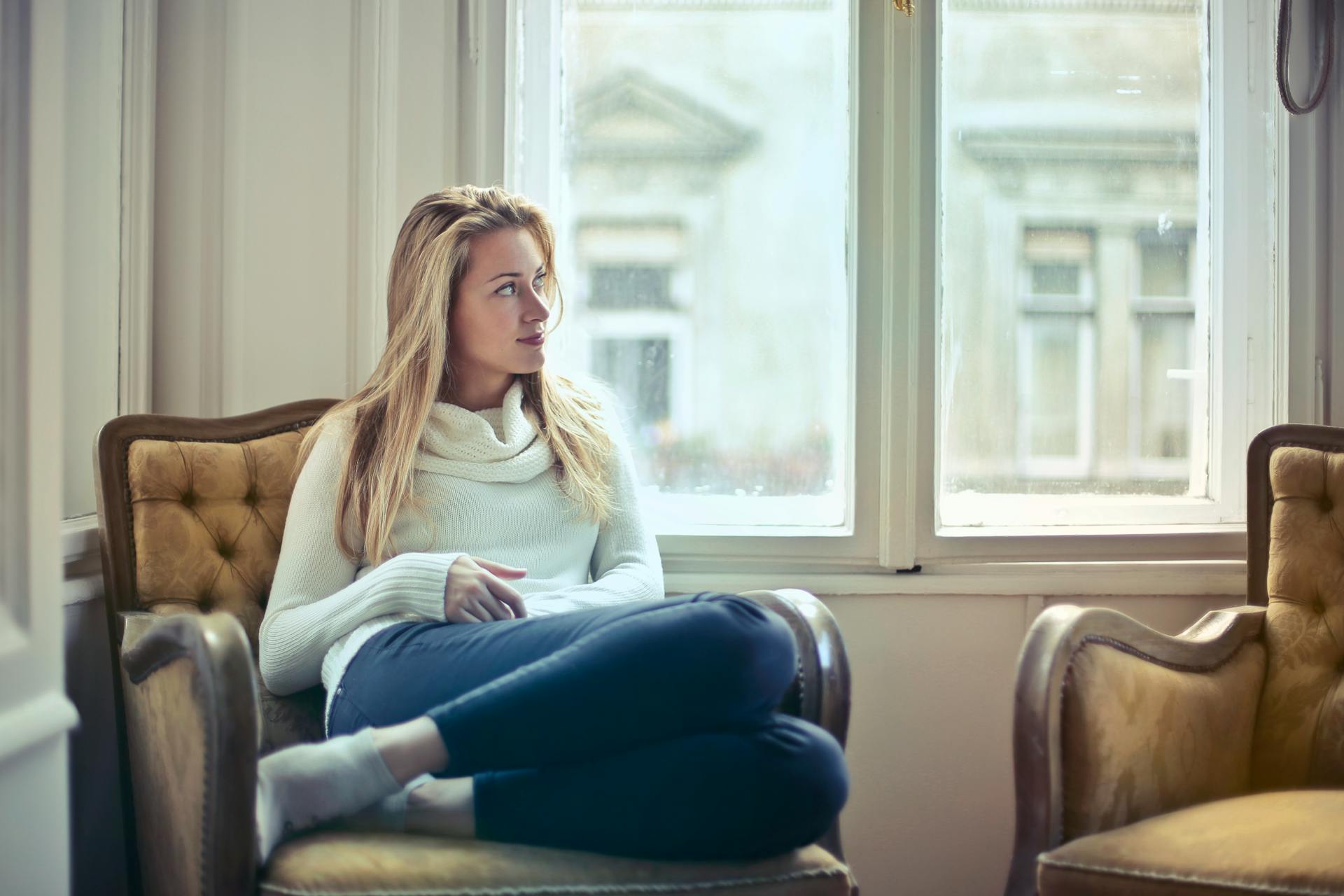 A woman sitting on a couch | Source: Pexels