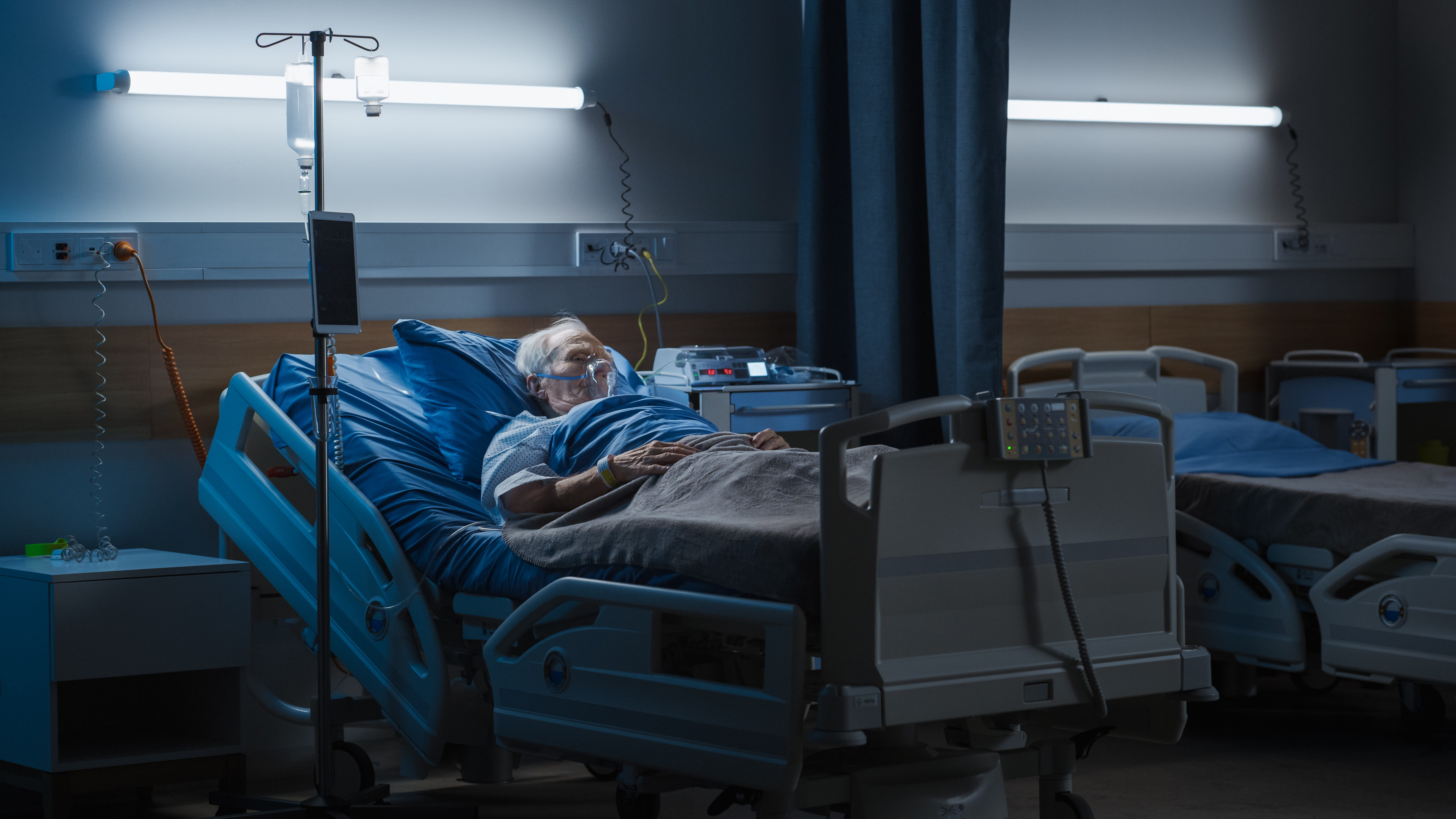 Old man wearing an oxygen mask asleep in his hospital bed | Source: Shutterstock