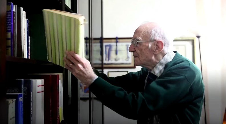 96-year-old Giuseppe Paterno, putting a book in a bookshelf | Photo: Youtube / Reuters