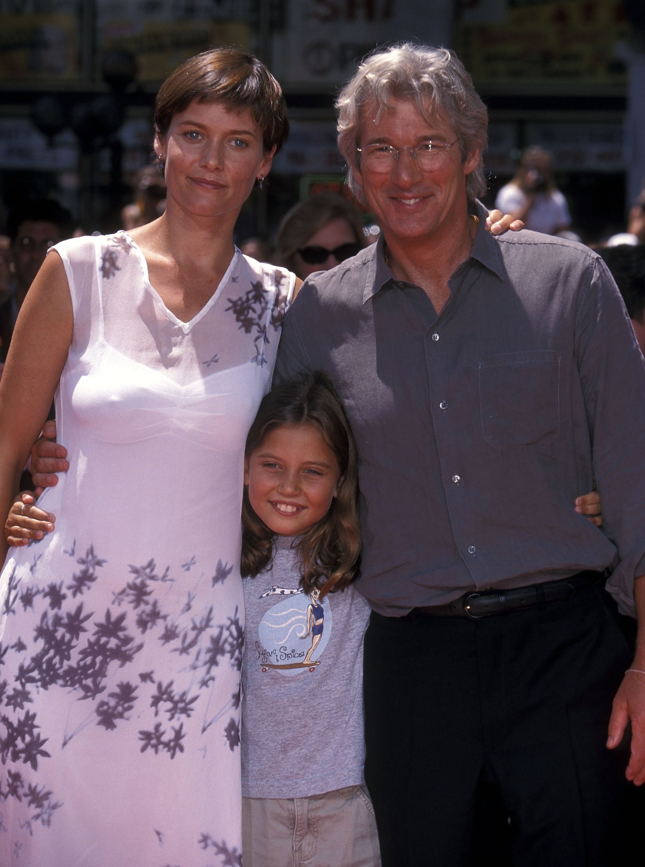 L'actrice Carey Lowell, sa fille Hannah Dunne et l'acteur Richard Gere assistent à la cérémonie des mains et des pieds dans le ciment de Richard Gere au Mann's Chinese Theatre le 26 juillet 1999 à Hollywood, en Californie. ┃Source : Getty Images