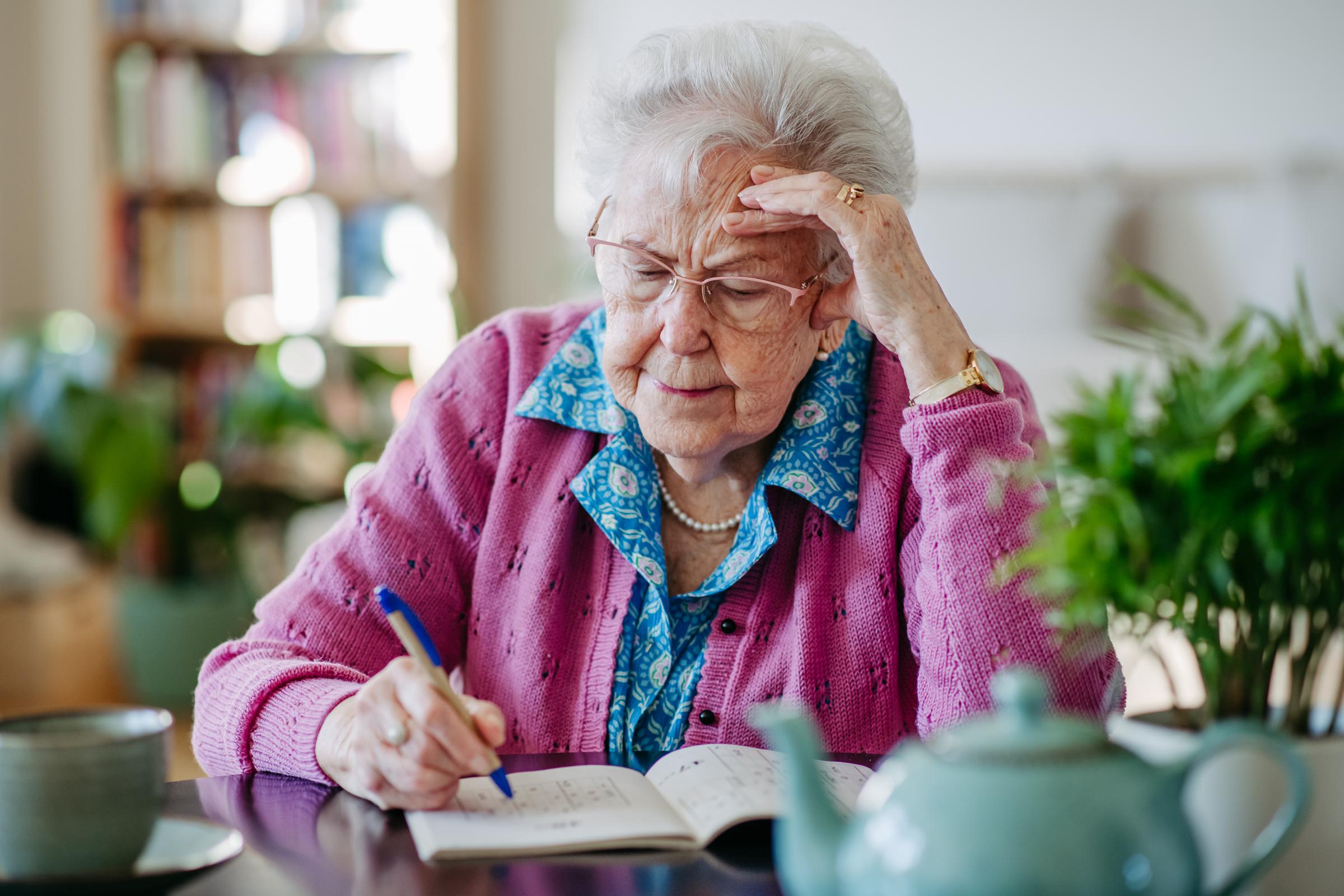 A distressed elderly woman solving sudoku puzzles at home | Source: Getty Images