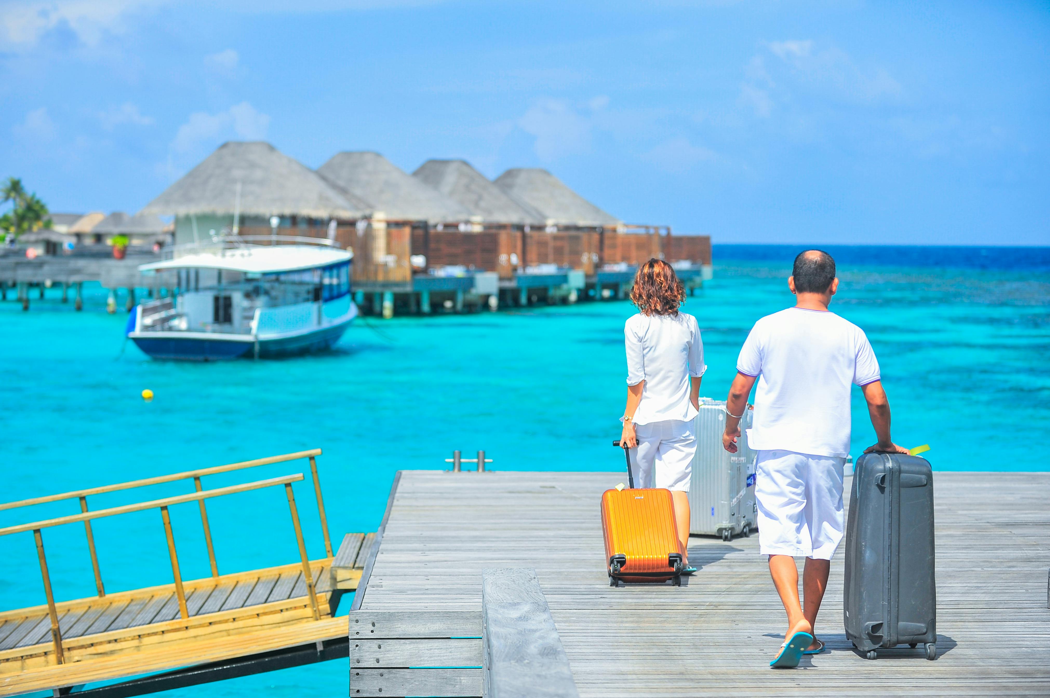 A man and a woman walking on the dock with suitcases | Source: Pexels