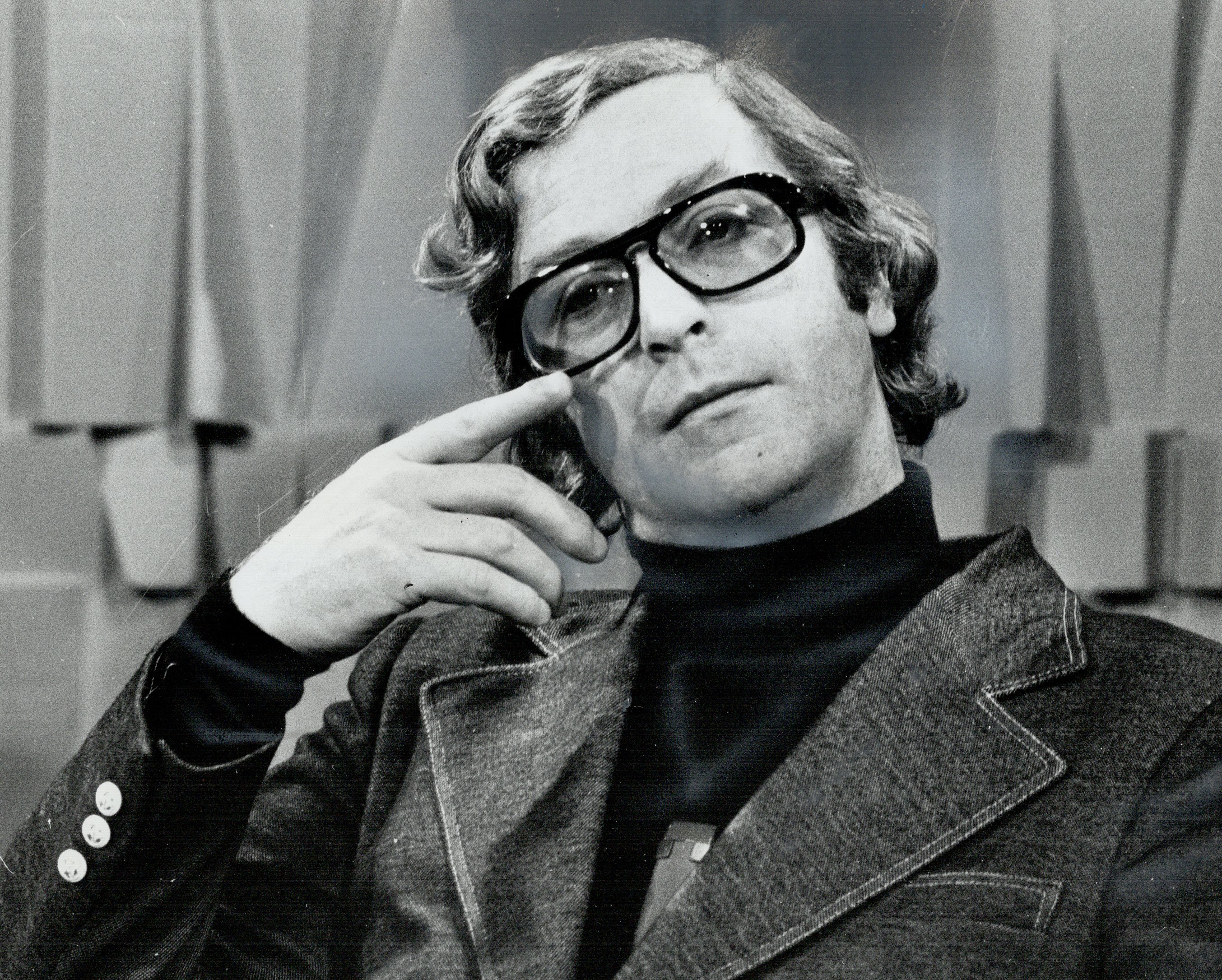 British film icon Sir Michael Caine captured appearing in deep-thought while wearing glasses paired with a denim jacket and a turtle neck in Toronto, Canada. / Source: Getty Images