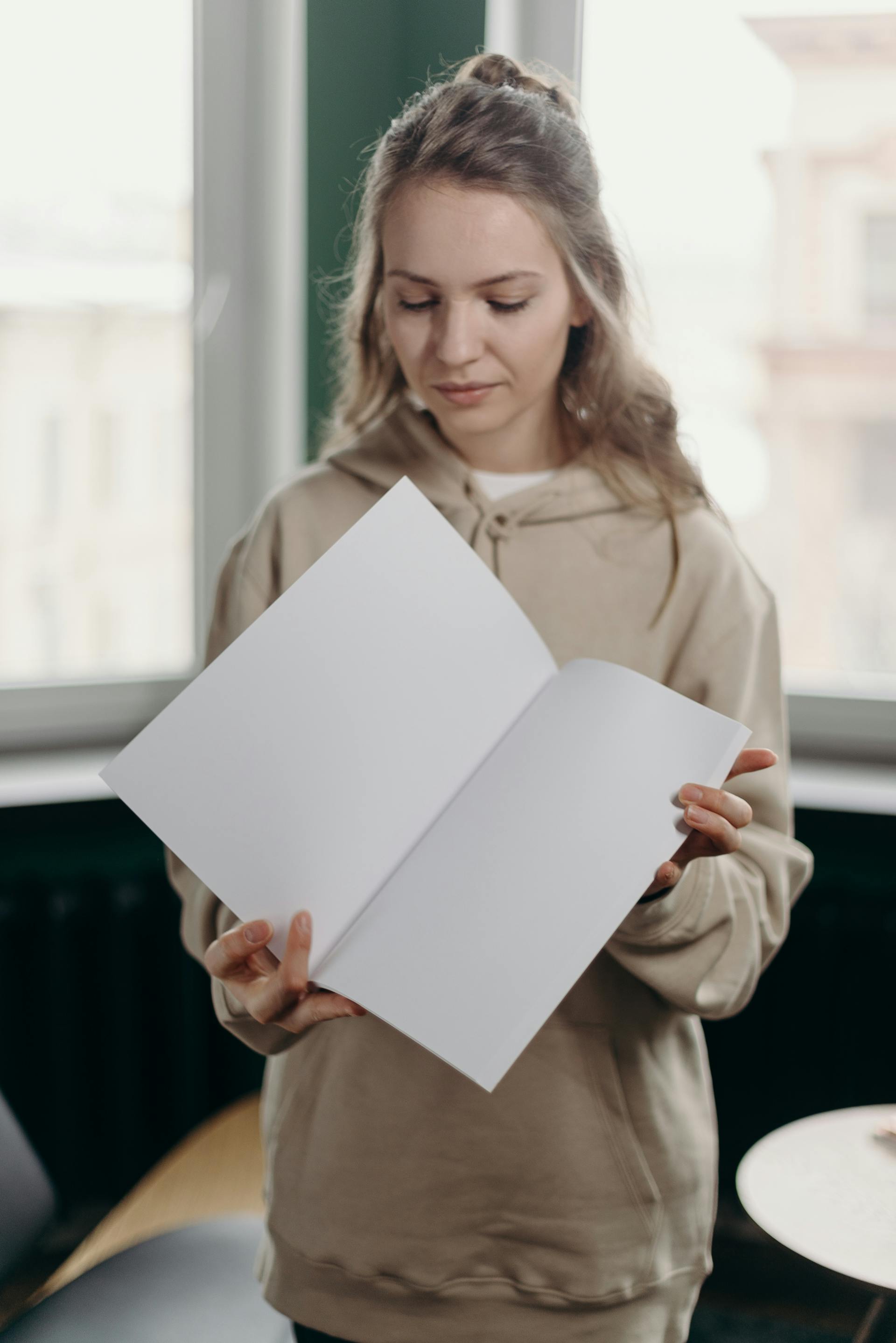A woman looking at a white paper in her hands | Source: Pexels