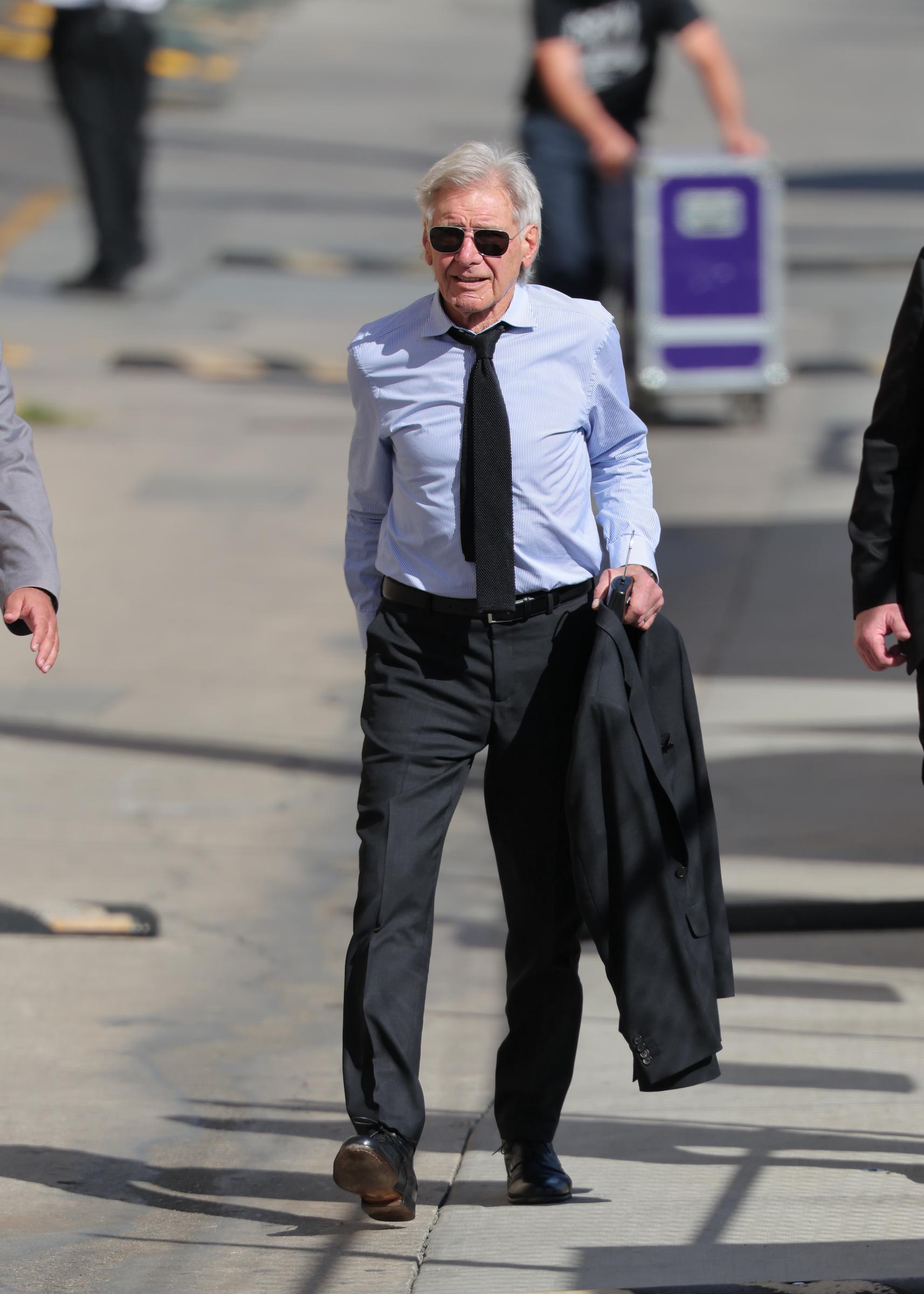 Moving with a confident, upright stride, Harrison Ford shows off a remarkably flat midsection and a broad chest while seen on March 10, 2026, in Los Angeles. Carrying his suit jacket in one hand, the actor's fitted striped shirt highlights a lean, highly active upper body that completely defies his age just months before turning 84. | Source: Getty Images