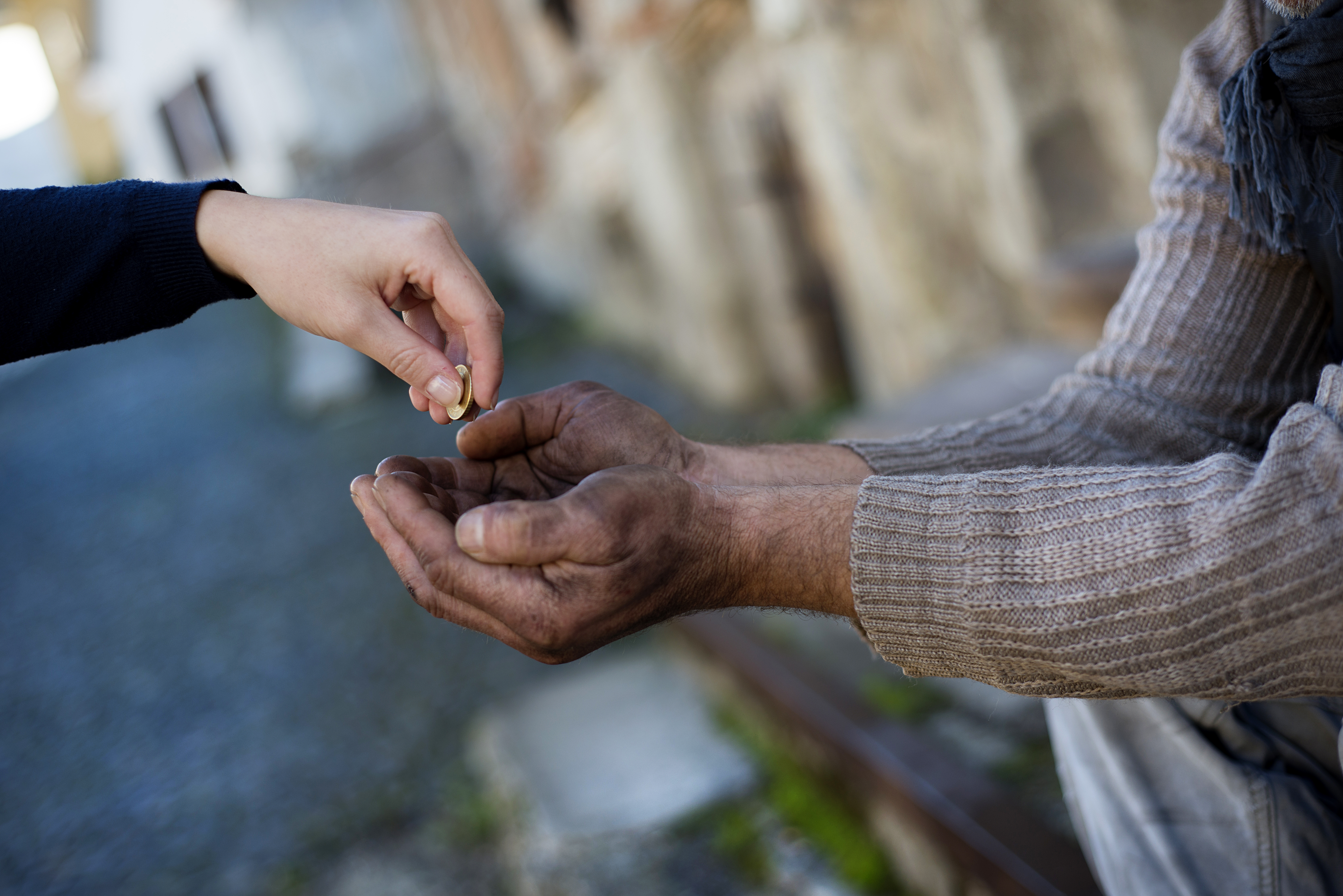 Someone giving change to a homeless person. | Source: Shutterstock