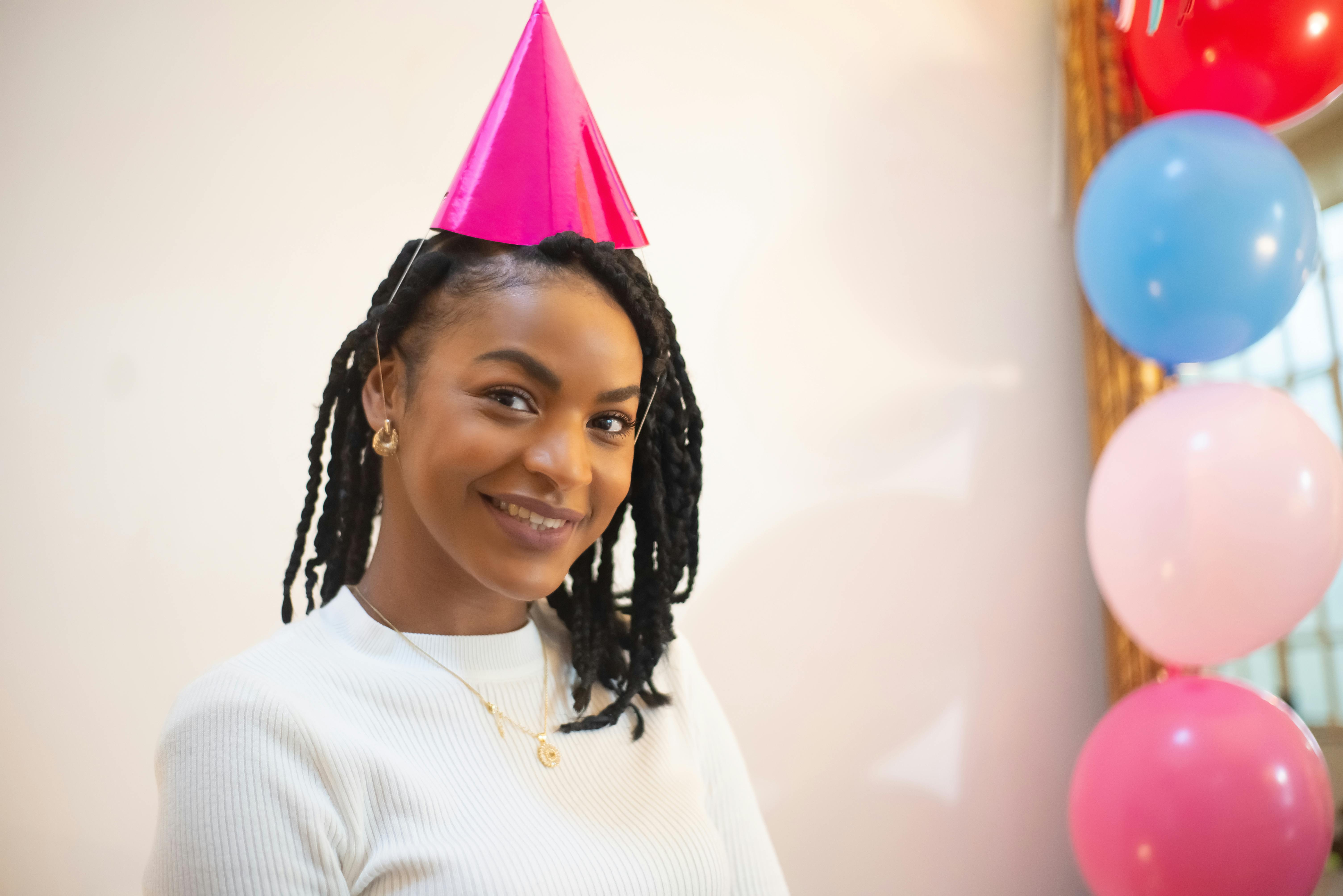 A happy woman wearing a party hat | Source: Pexels