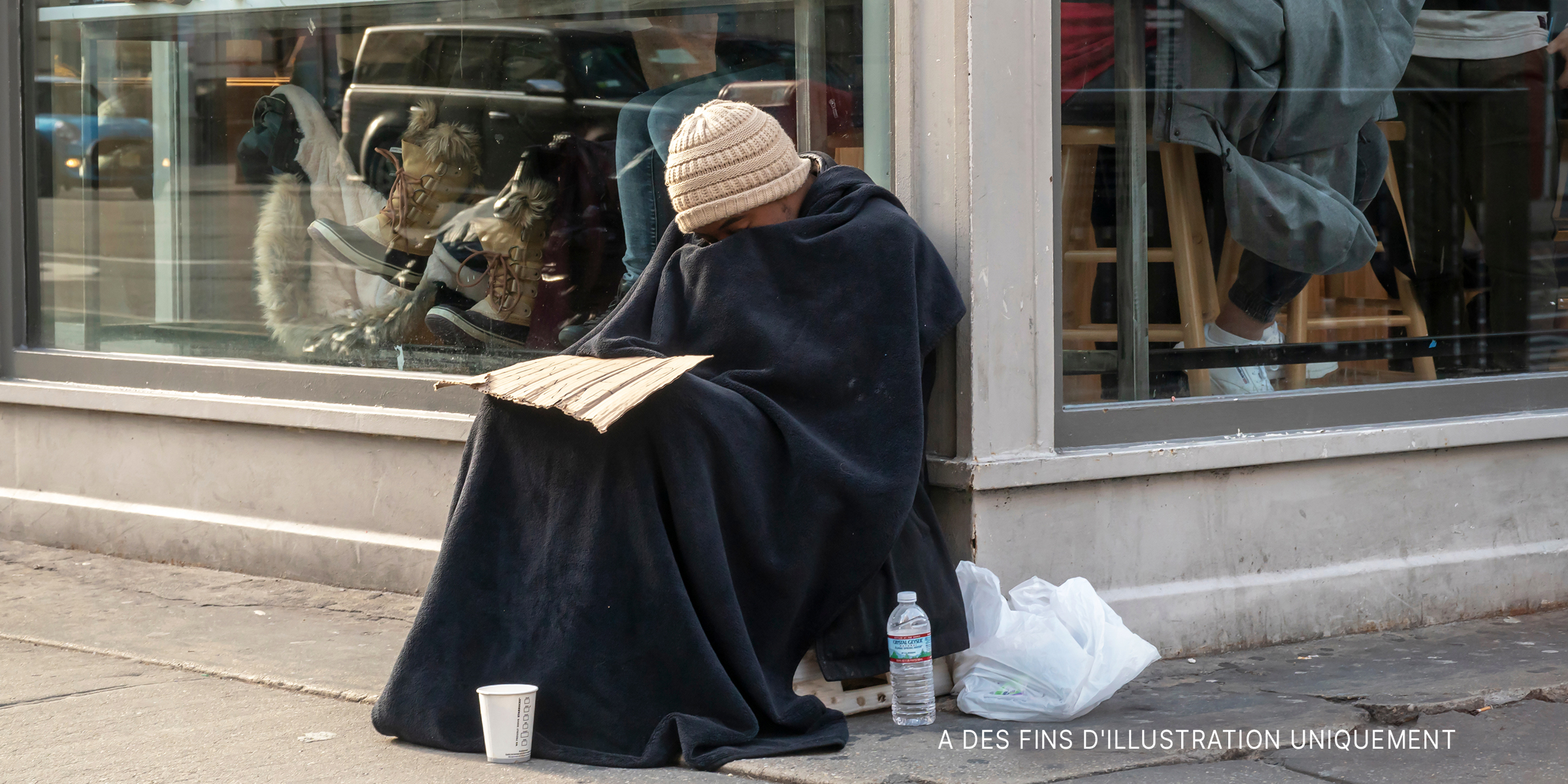 Un sans-abri assis à l'extérieur d'un restaurant | Source : Shutterstock