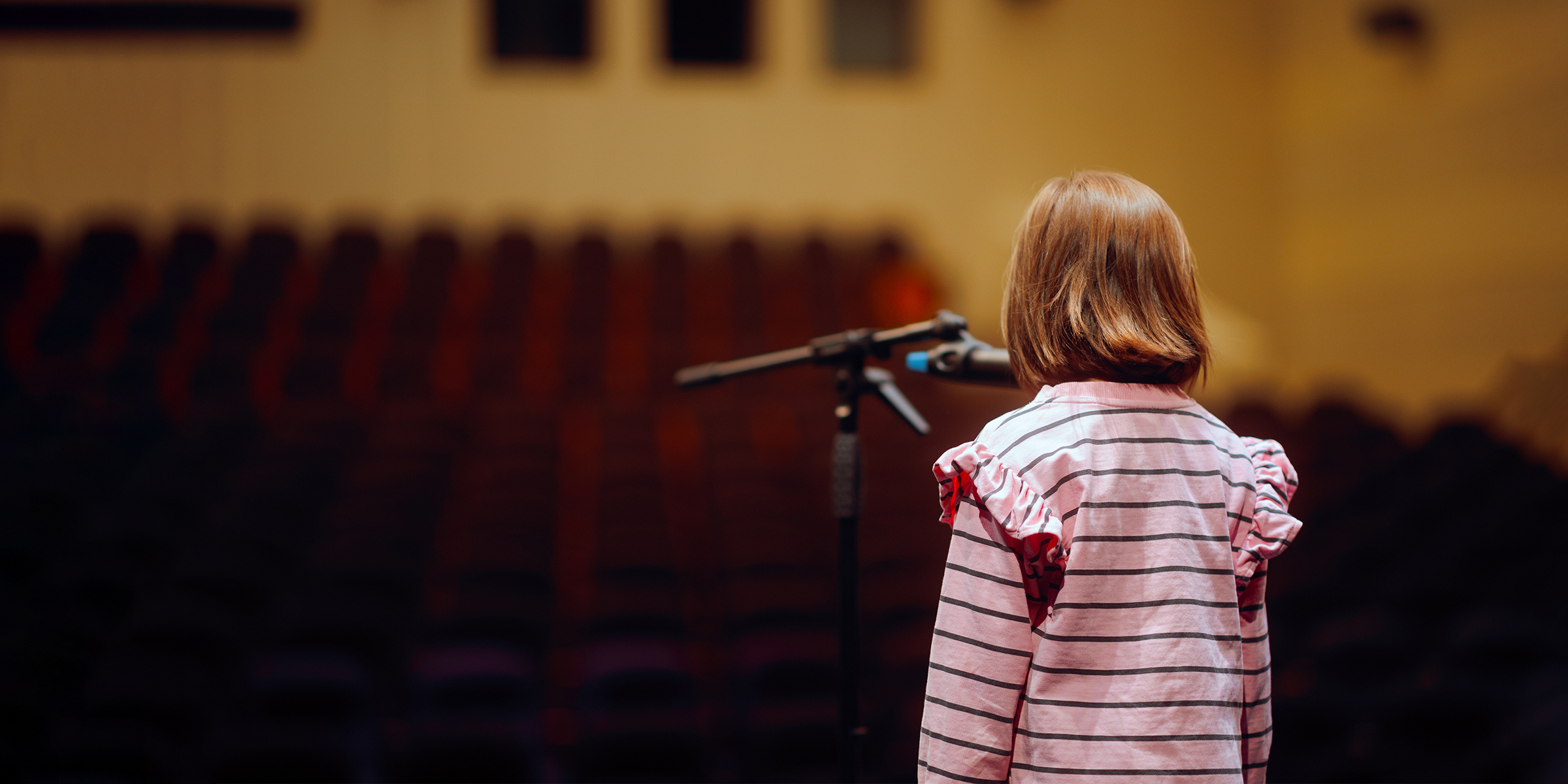 A girls standing in front of a microphone | Source: Shutterstock