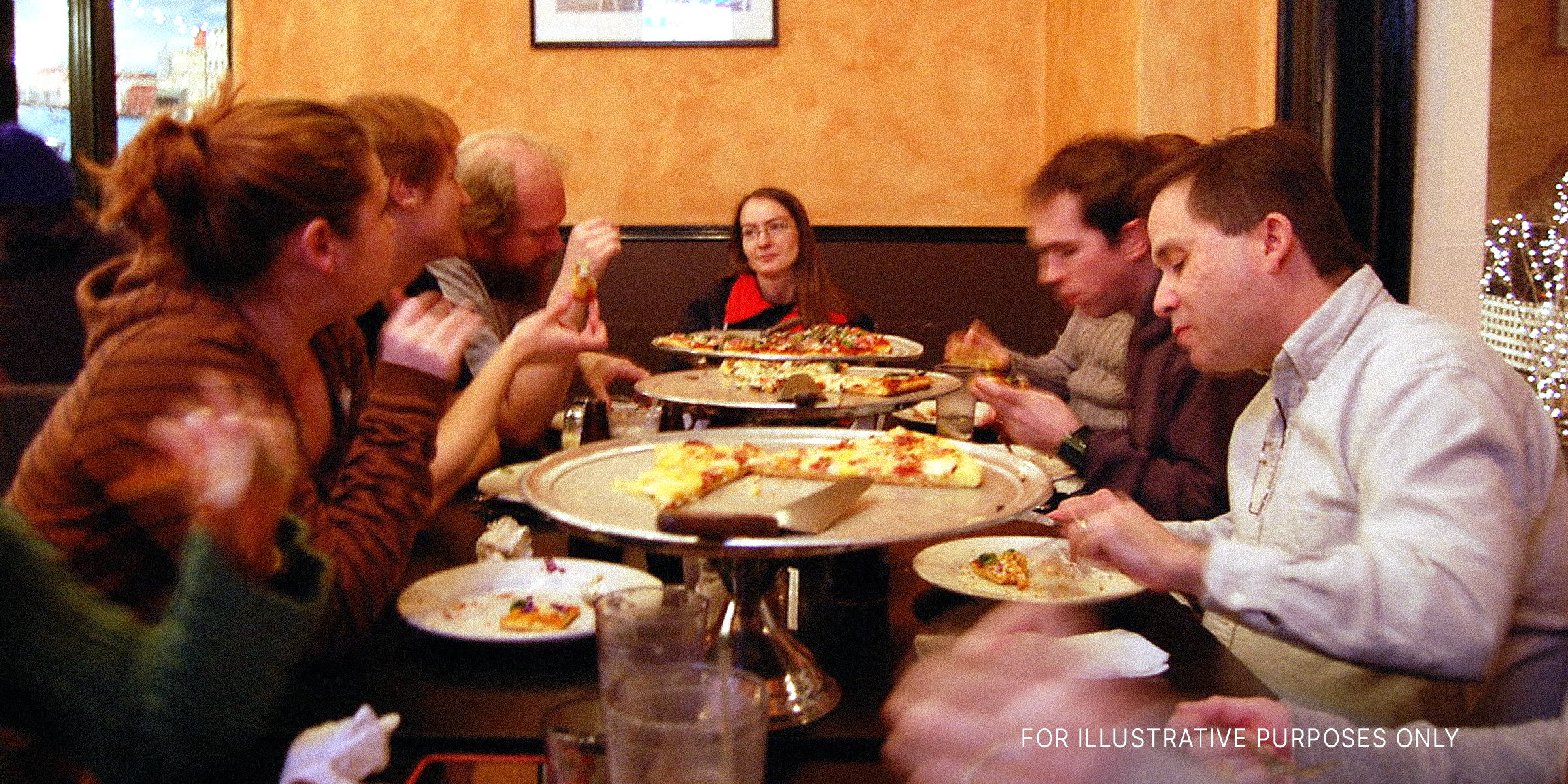 People sitting around a table and eating | Source: Flickr