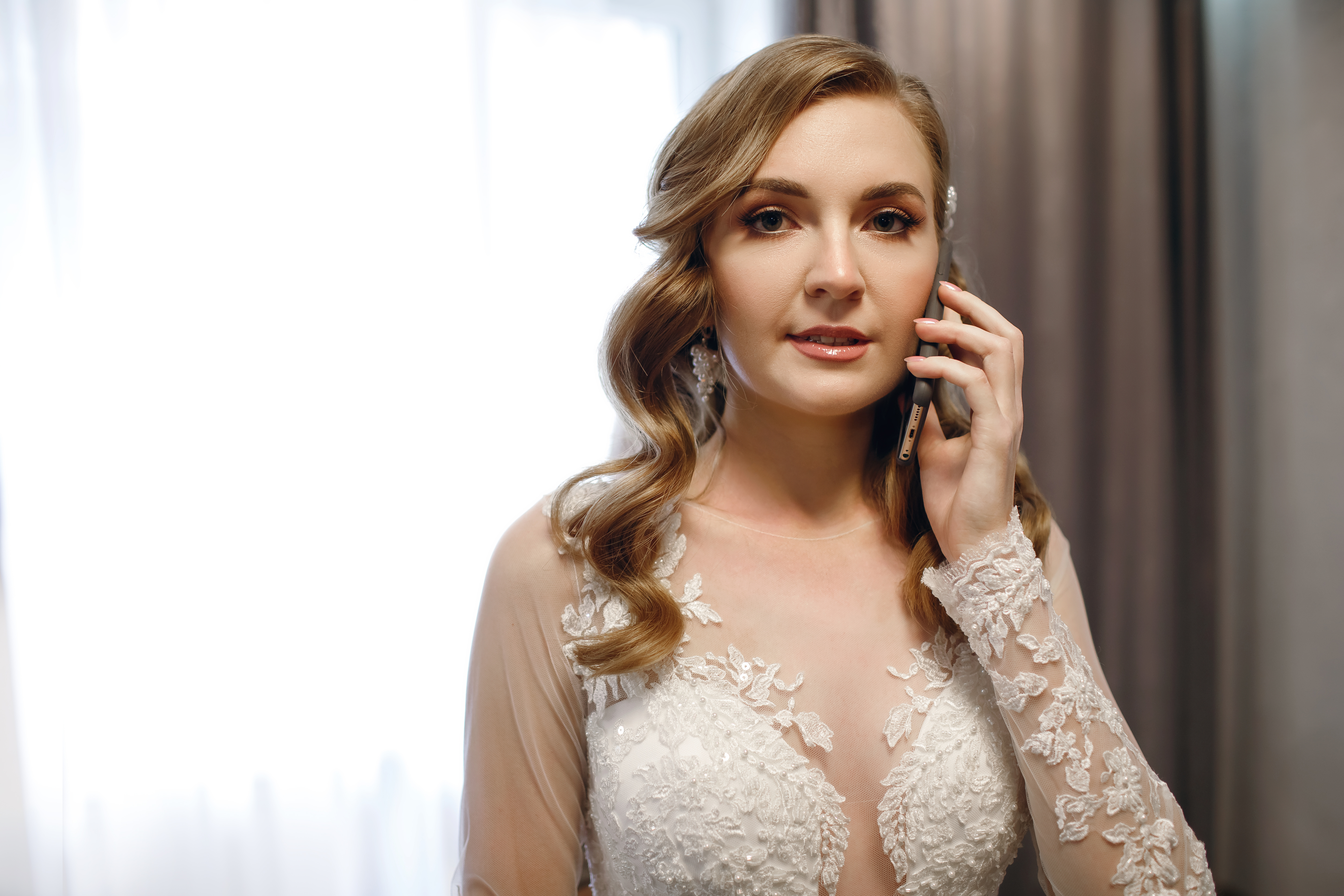 An angry young woman in a wedding dress talking on her phone | Source: Shutterstock