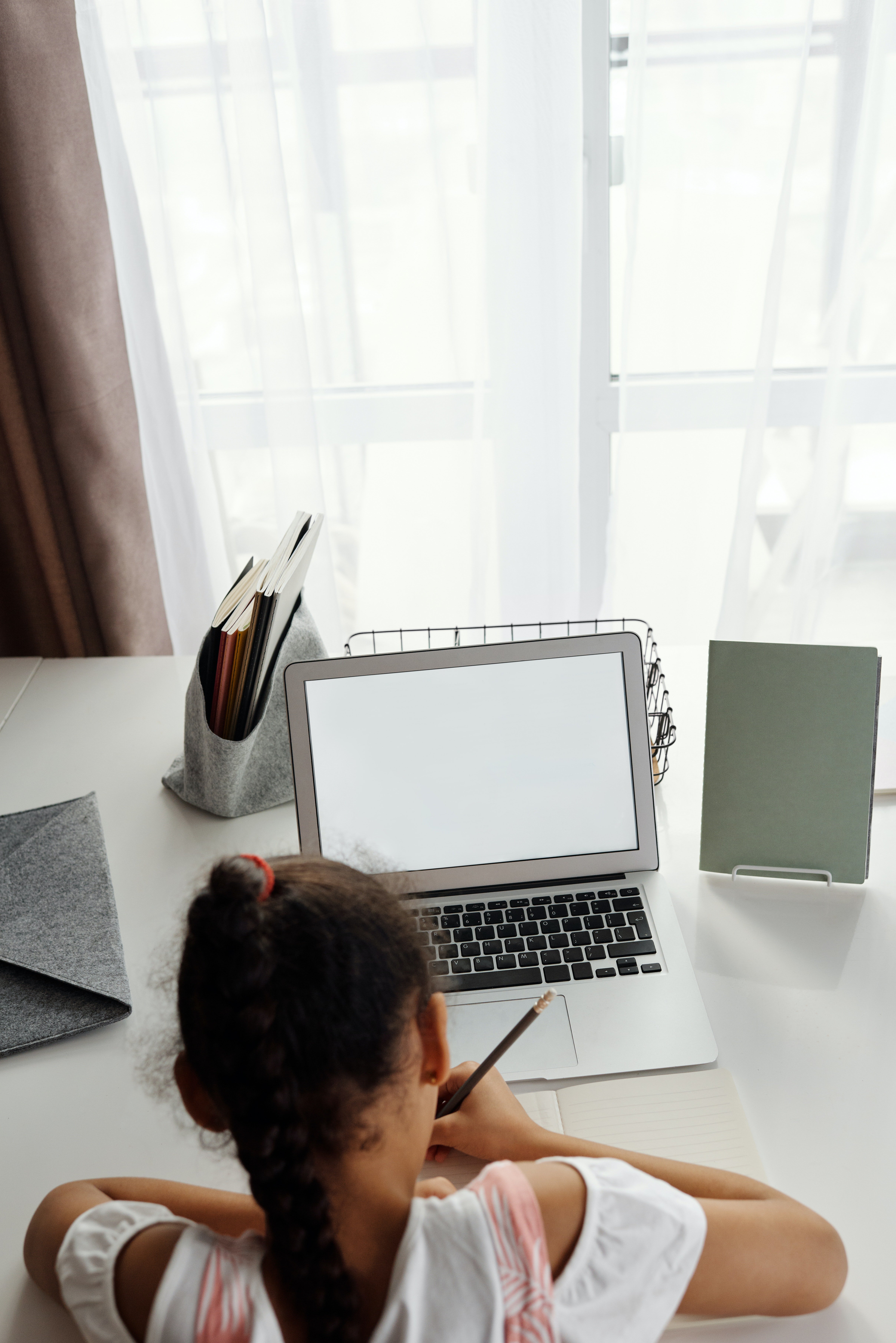 Une petite fille fait son devoir en ligne. | Photo : Pexels