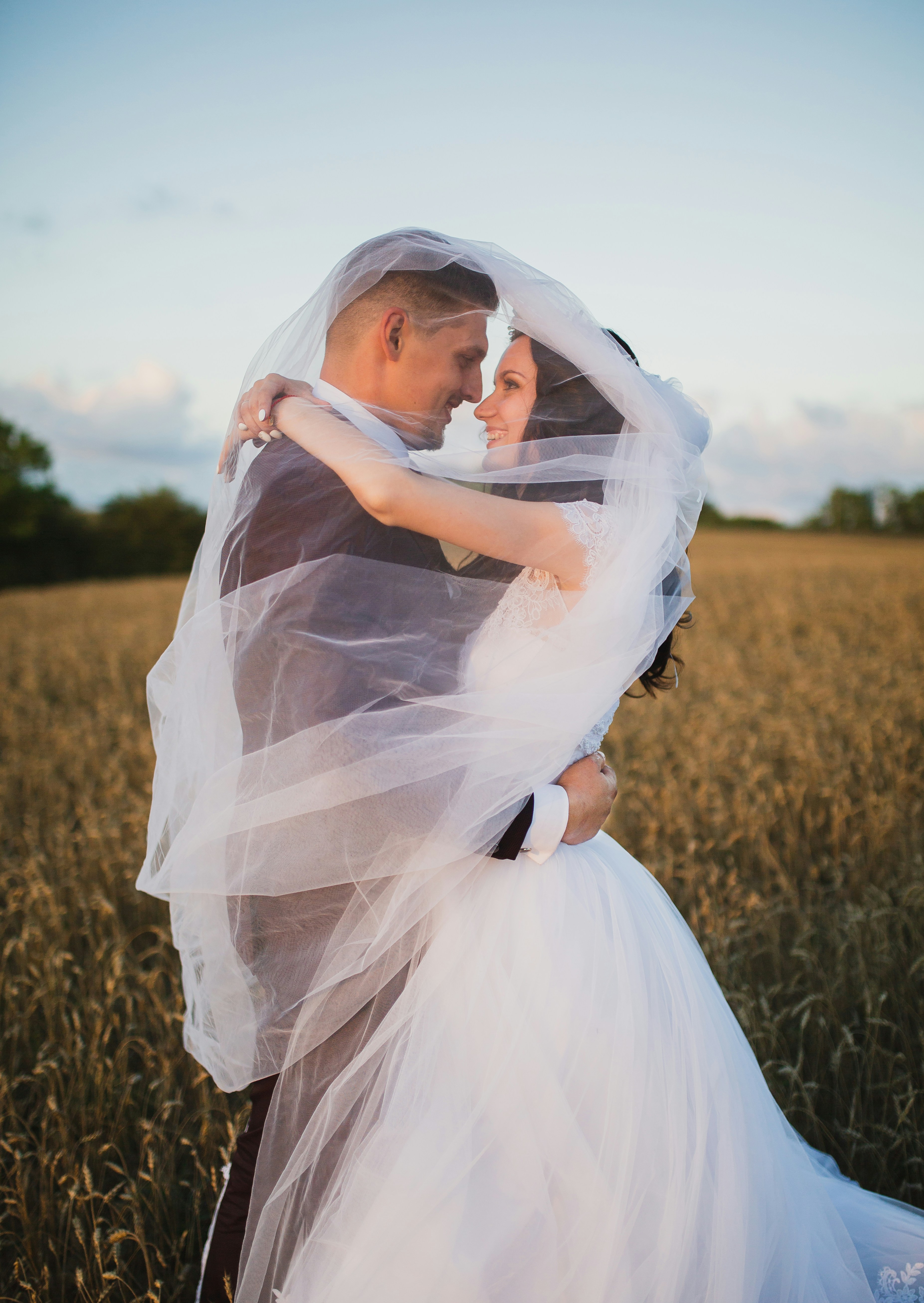 A bride and groom with their arms around each other outdoors | Source: Unsplash