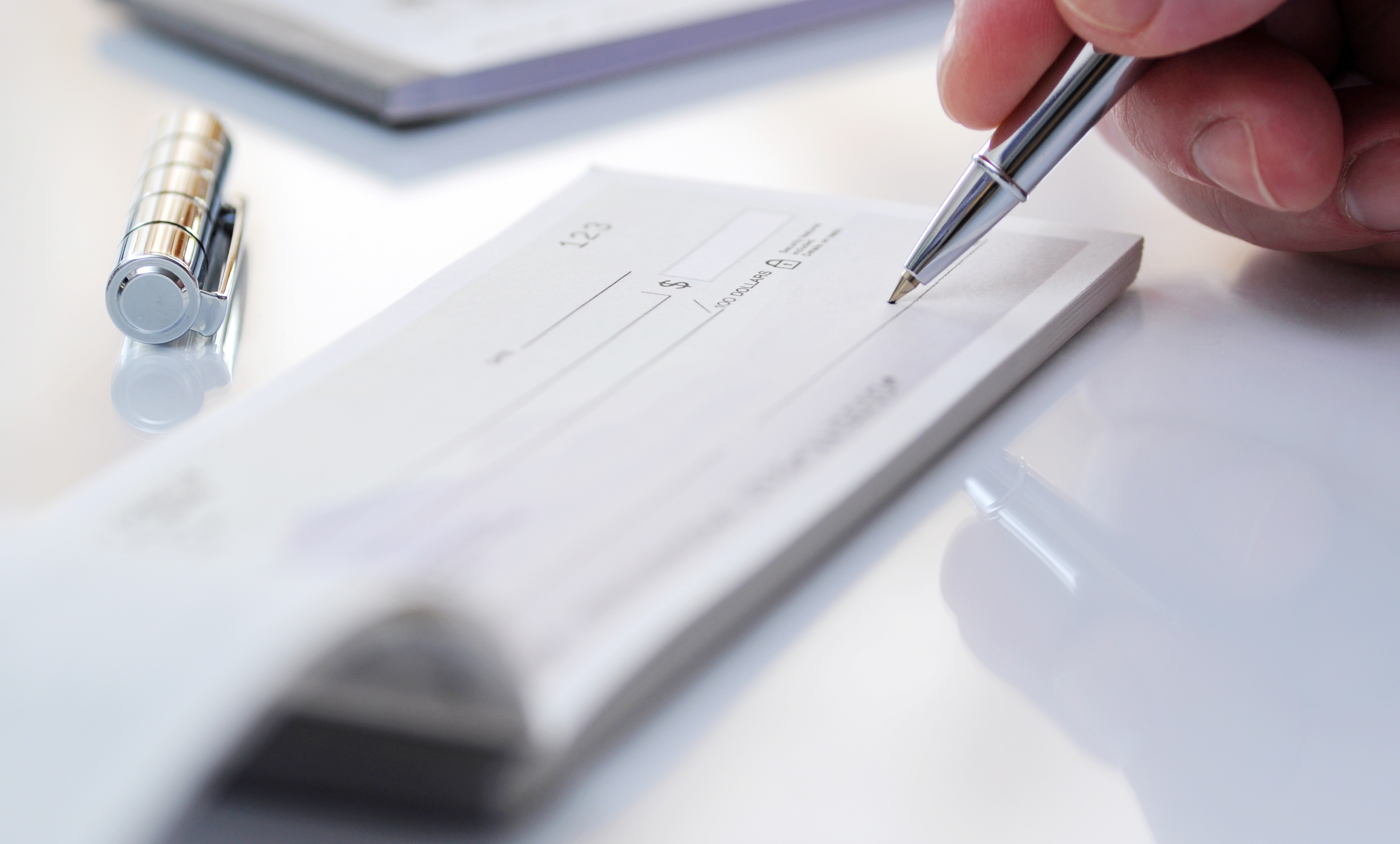 Business man prepare writing a check. | Source: Shutterstock