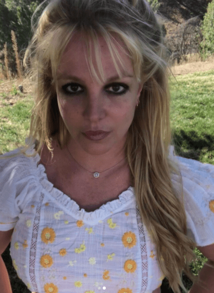 Britney Spears wearing a white blouse with orange flowers on it | Photo: Instagram.com/britneyspears