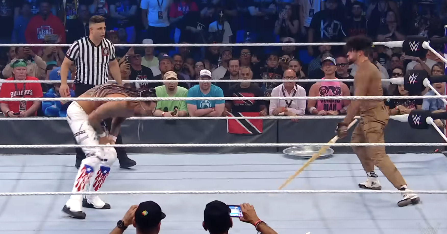 Bad Bunny prepares to hit a bent-over Damian Priest with a kendo stick during their match, from a post dated September 20, 2024. | Source: YouTube/WWE
