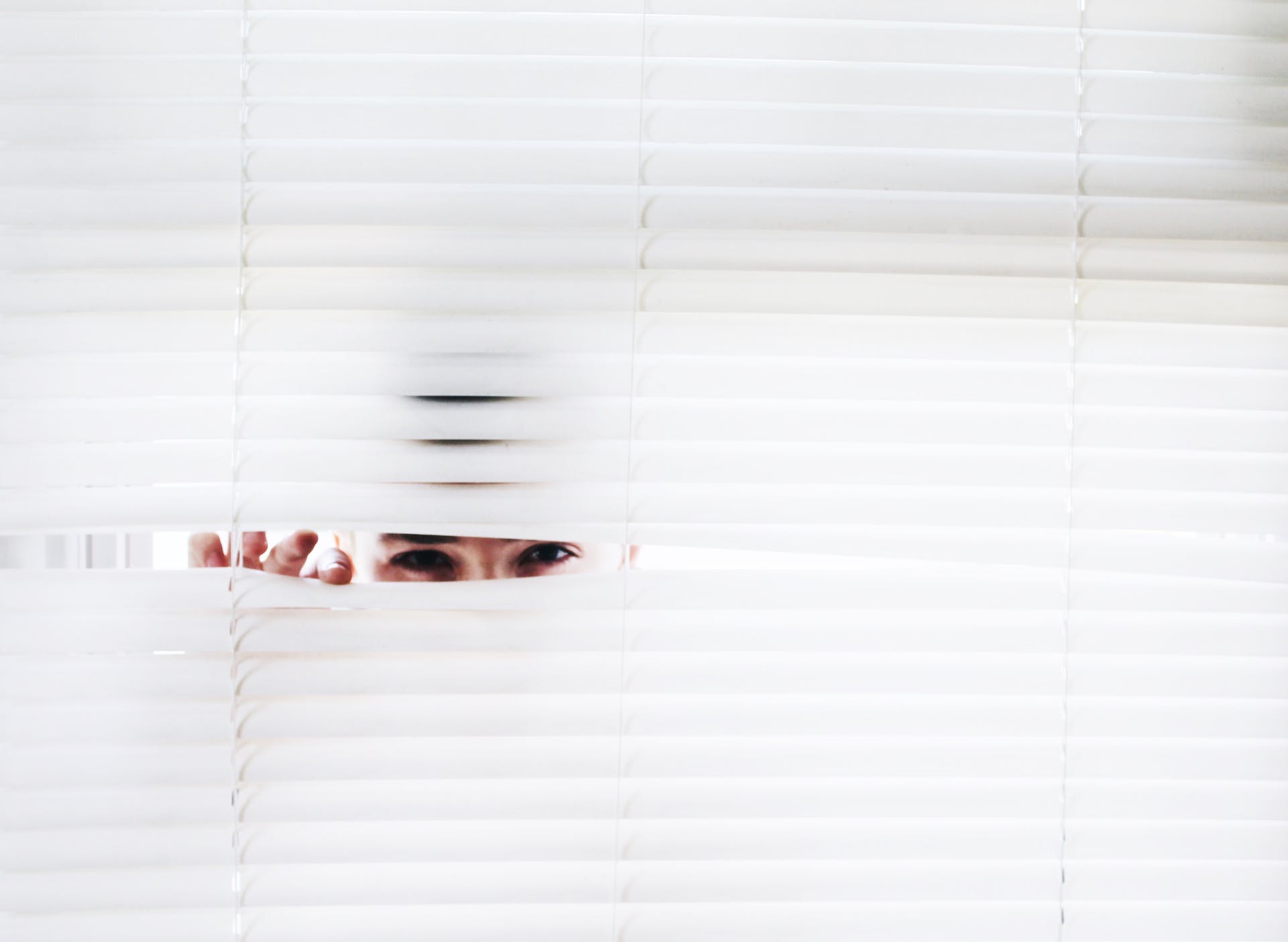 A person peeking through blinds | Source: Pexels