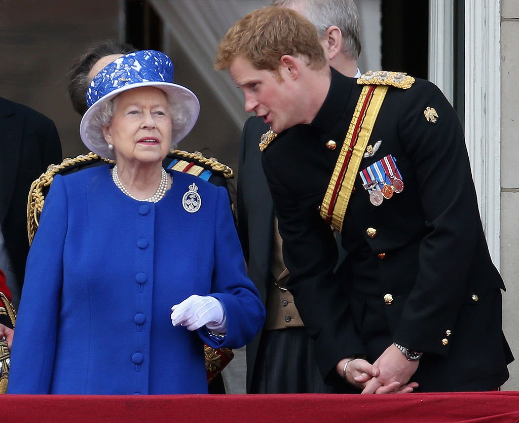 Prinz Harry unterhält sich mit Königin Elizabeth II. Auf dem Balkon des Buckingham Palace am 15. Juni 2013 in London, England. | Quelle: Getty Images