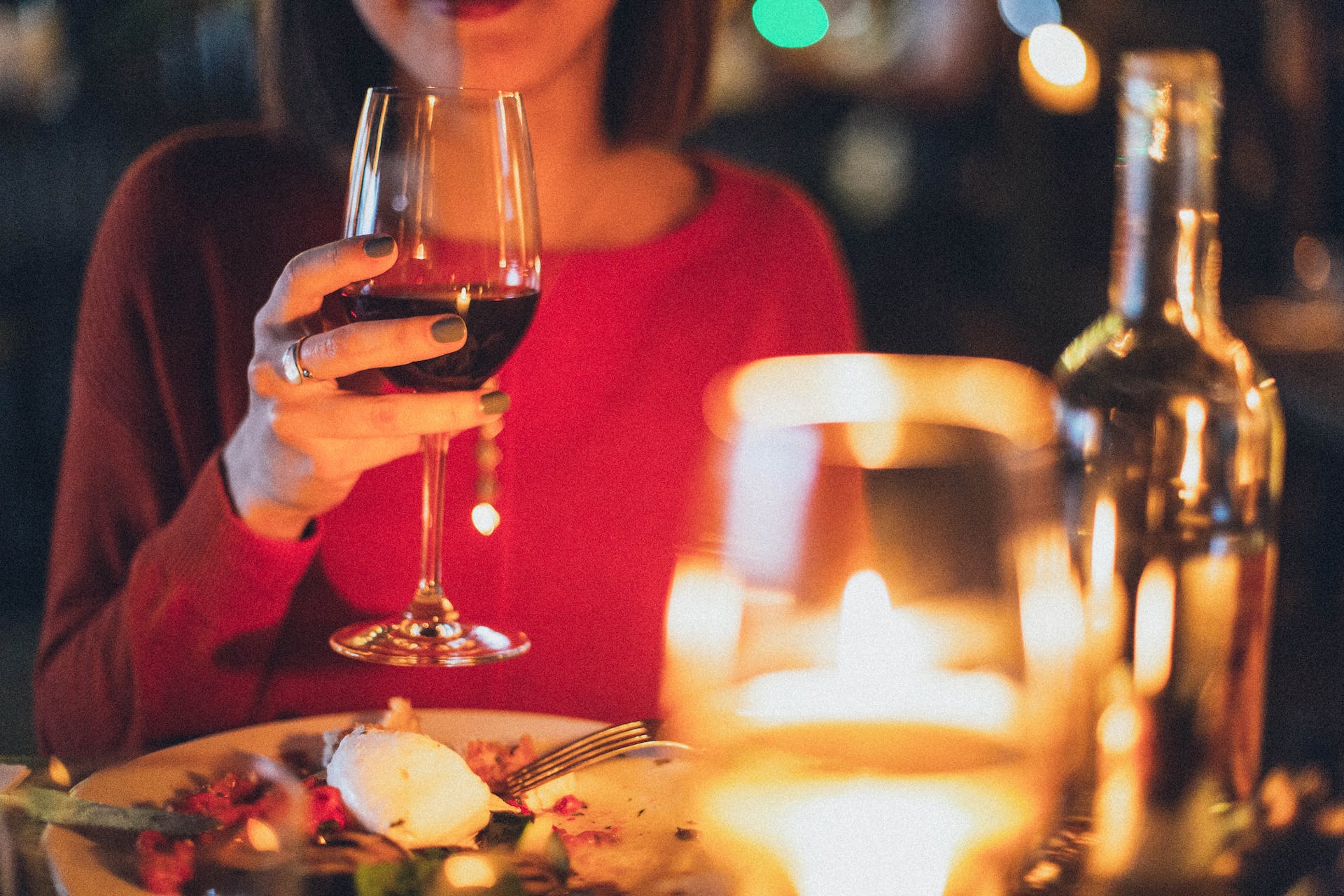 Una mujer sosteniendo una copa de vino durante la cena en un restaurante | Fuente: Pexels