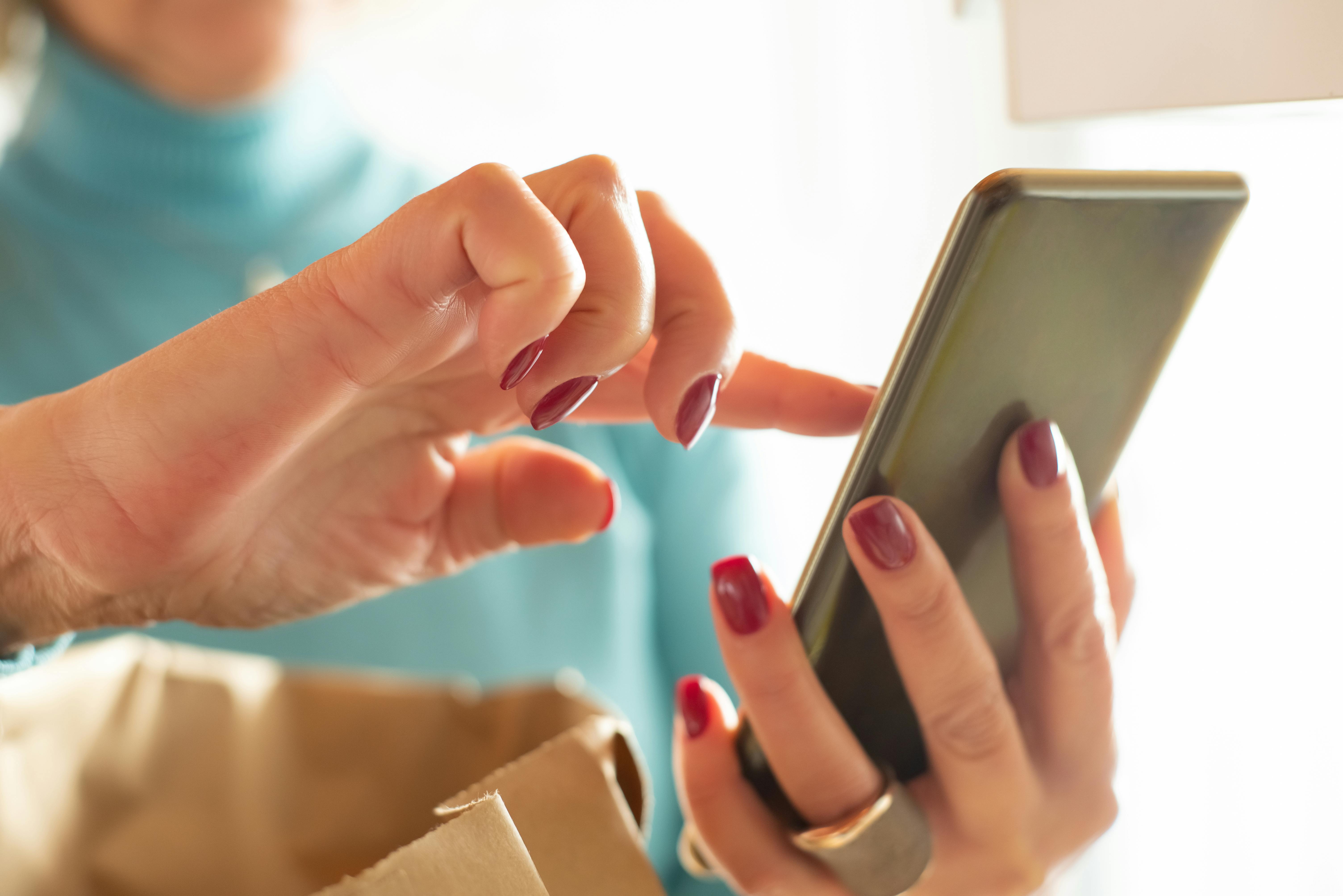 A woman holding a phone in her hands | Source: Pexels